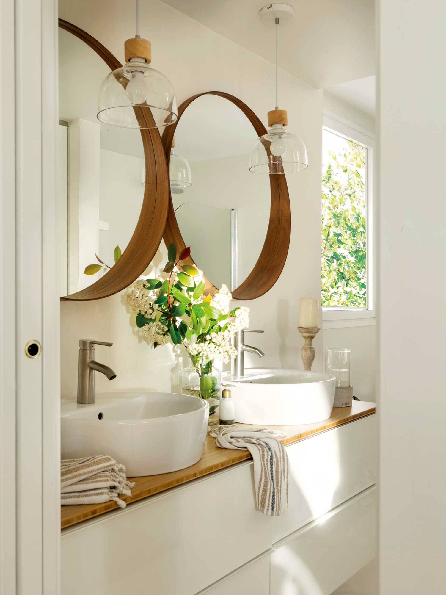 Baño con mueble blanco y espejos con marco de madera