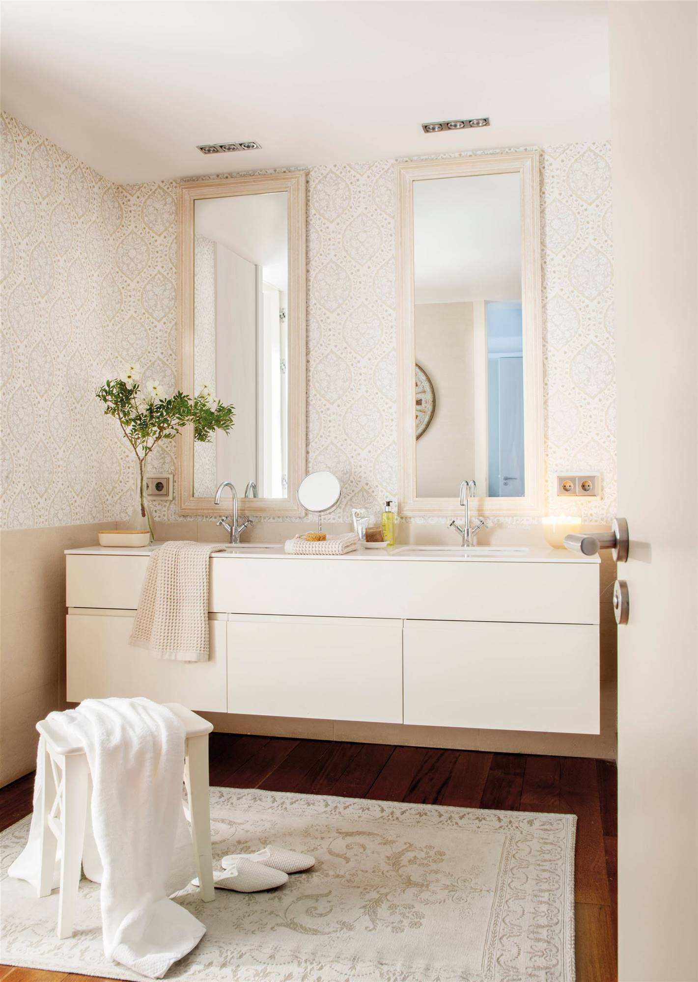 Baño con papel pintado y alfombra estampada de estilo afrancesado.