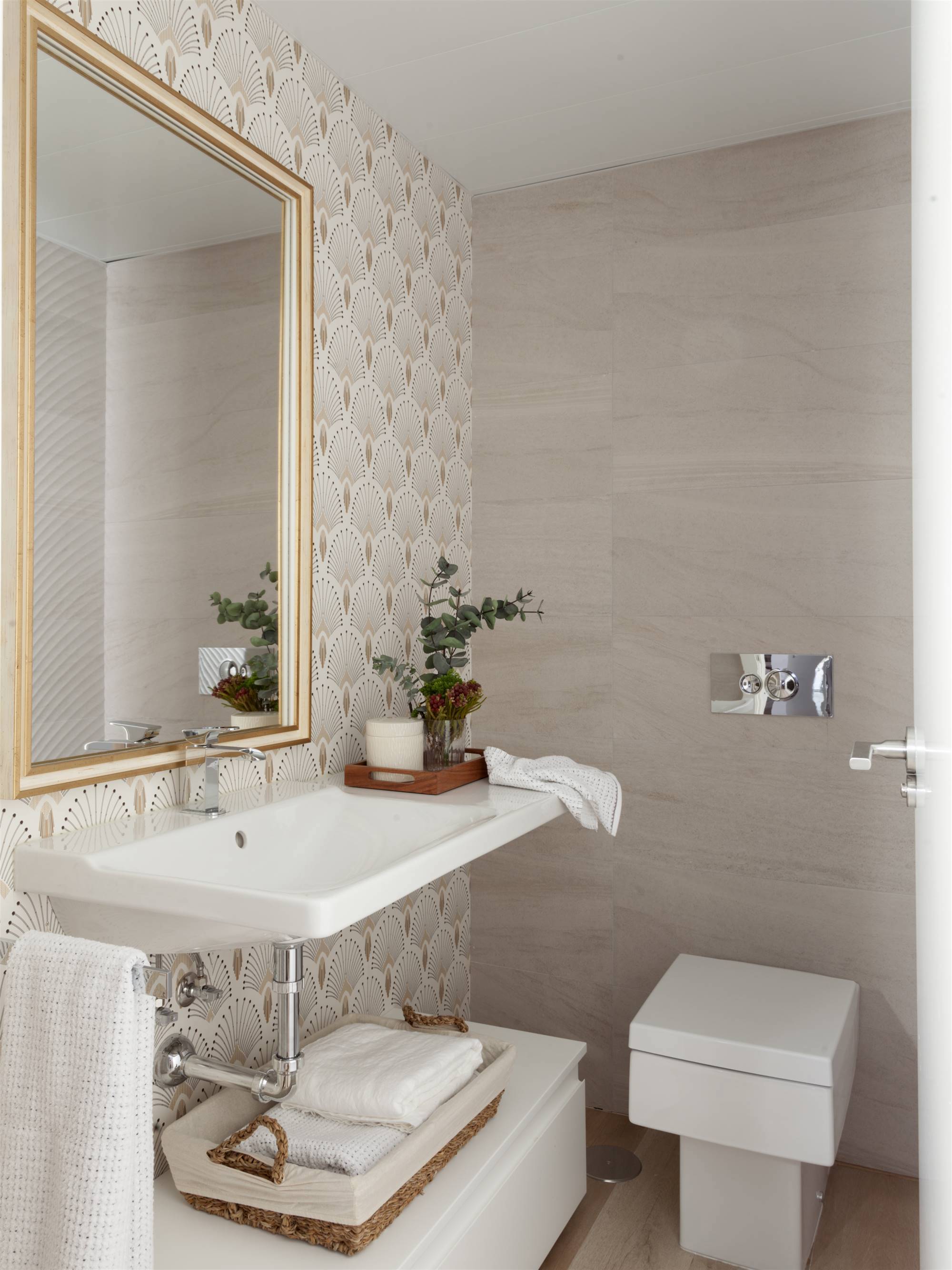 Baño pequeño con papel pintado y espejo con marco dorado
