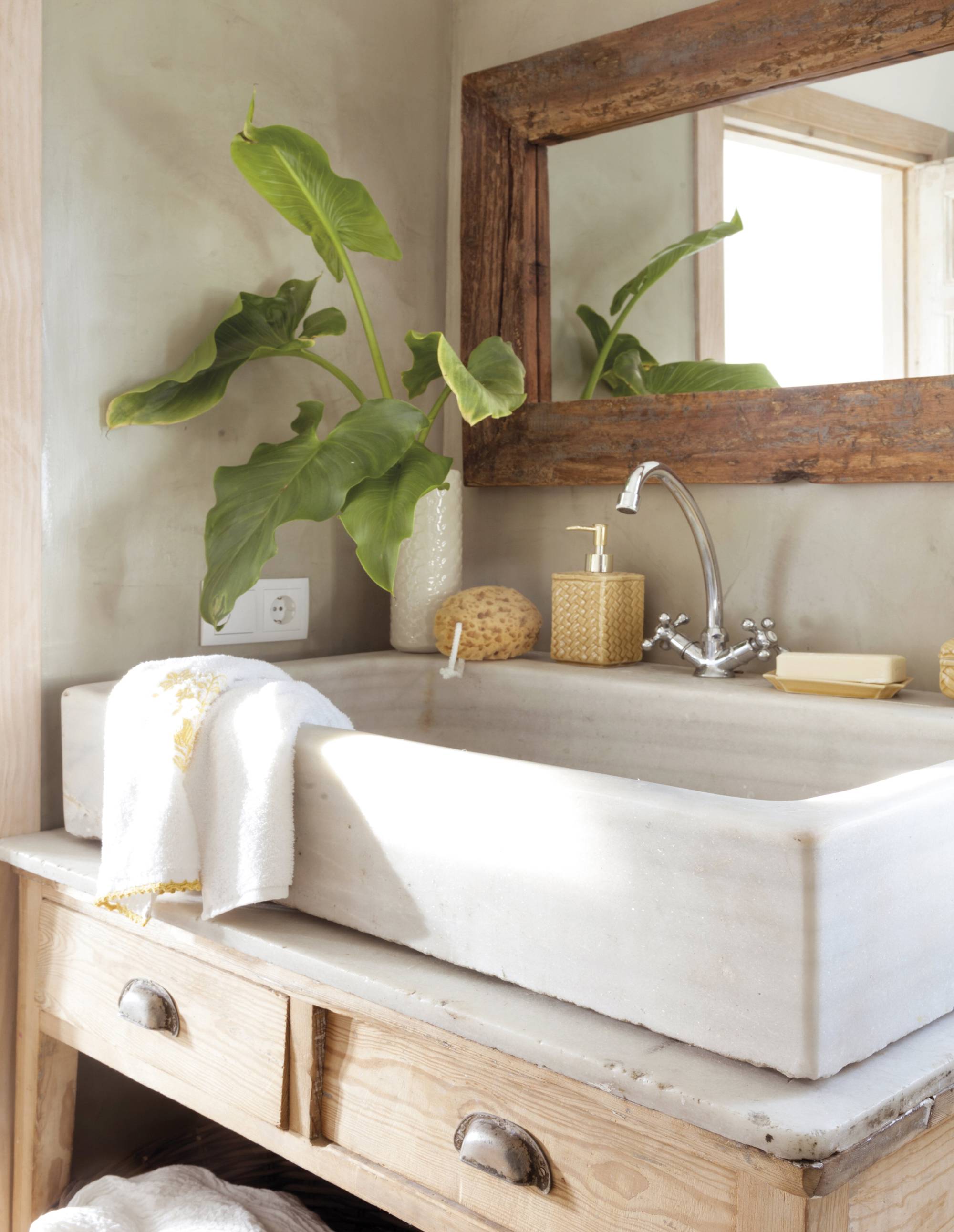 Baño con lavamanos de mármol antiguo y espejo de madera.