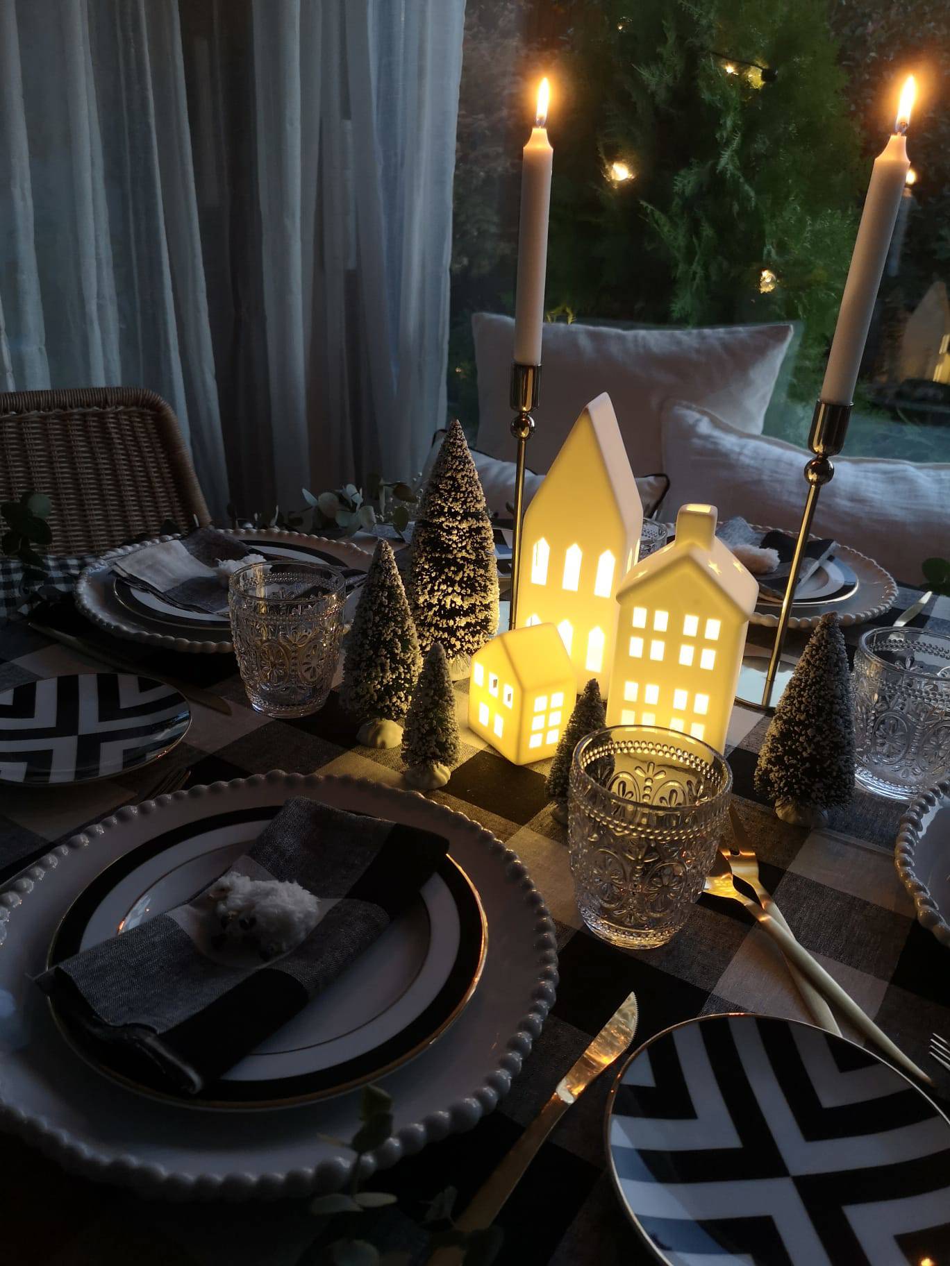 Comedor con mesa navideña con lámpara de mesa de IKEA, velas y arbolitos decorativos.