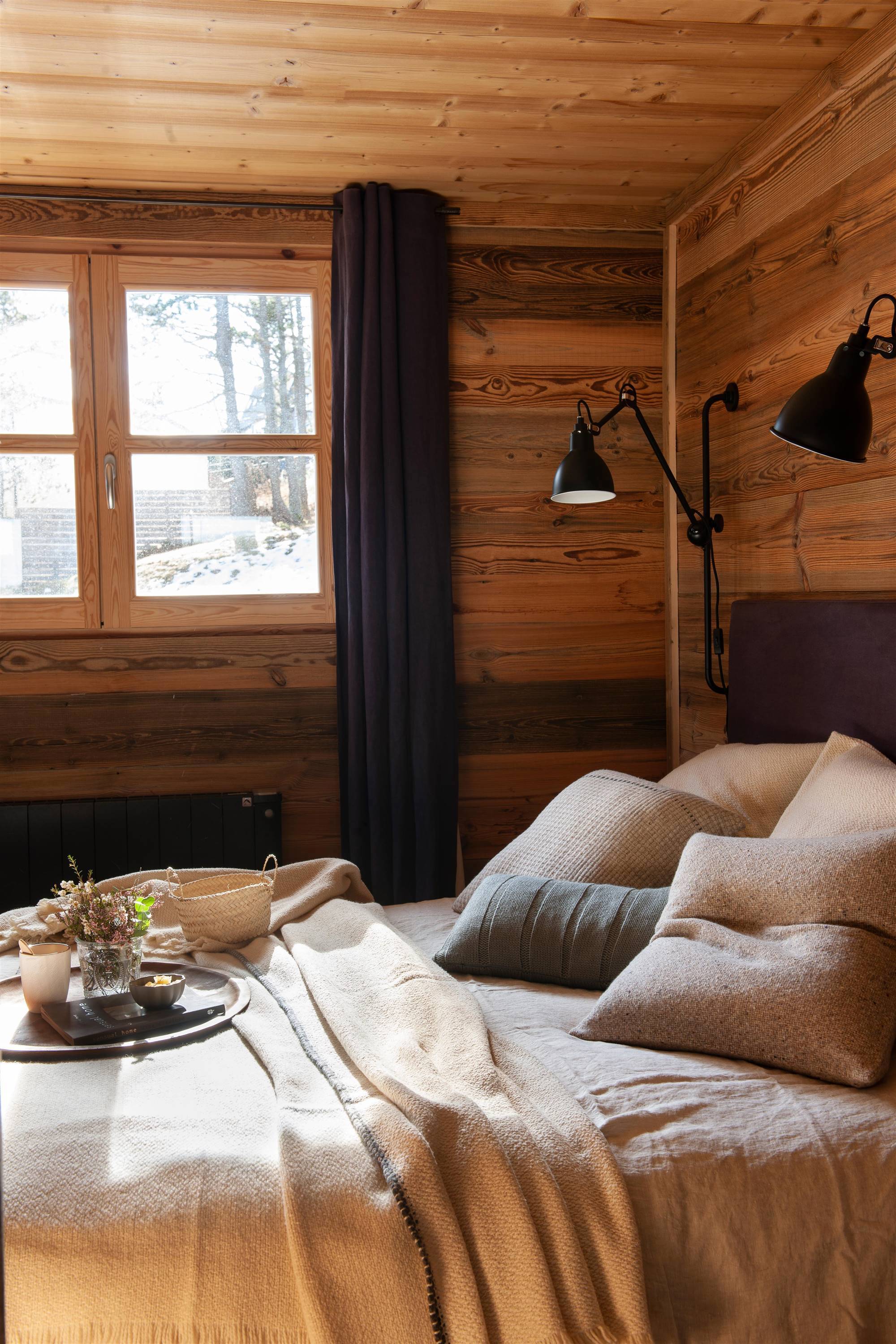 Dormitorio revestido eLn madera con detalles en negro.