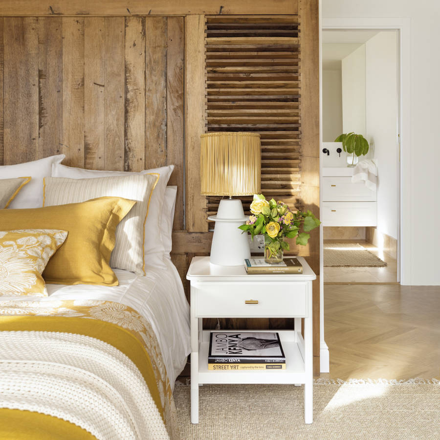 dormitorio con cabecero de madera y mesita blanca