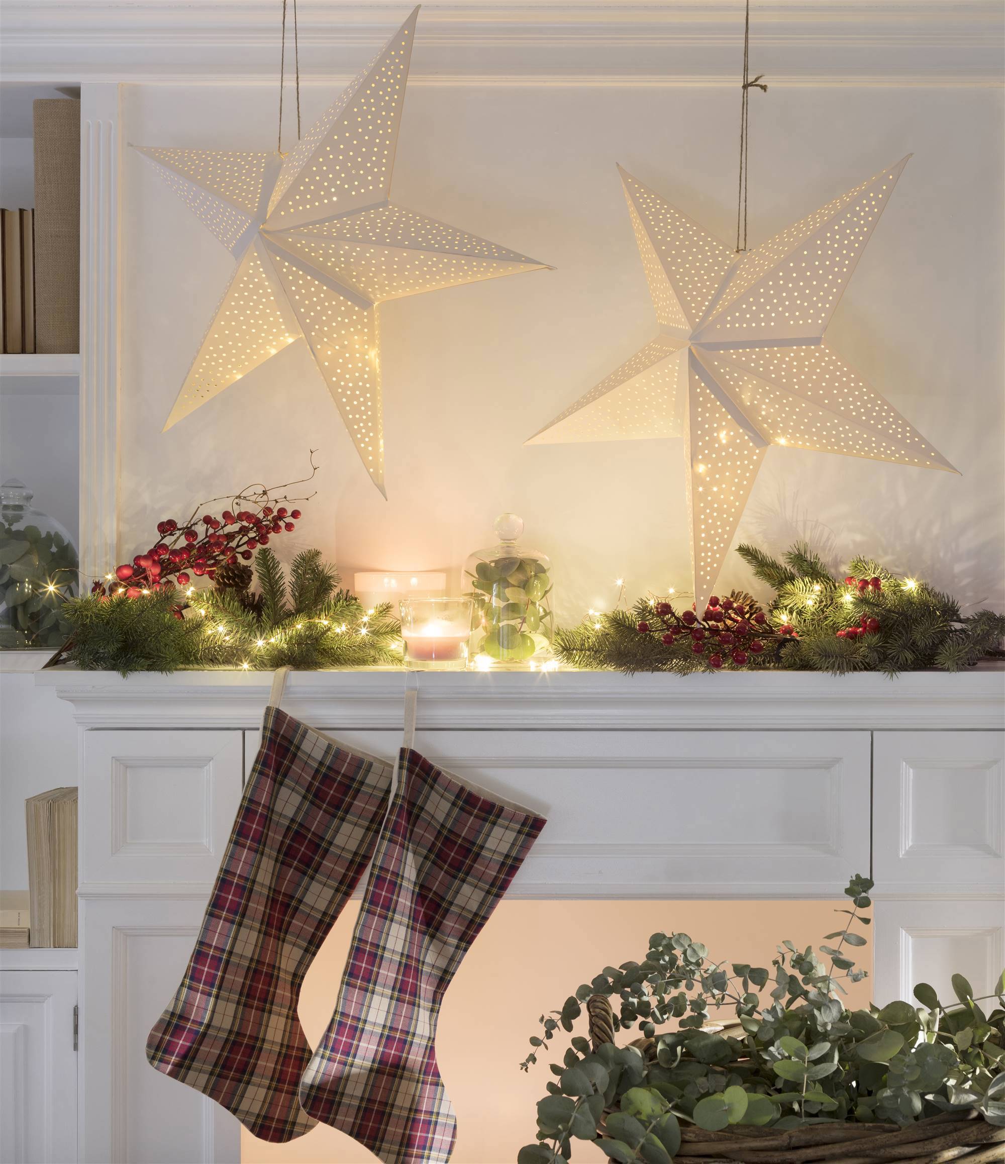 Calcetines de navidad colgados de la chimenea y luces luminosas.