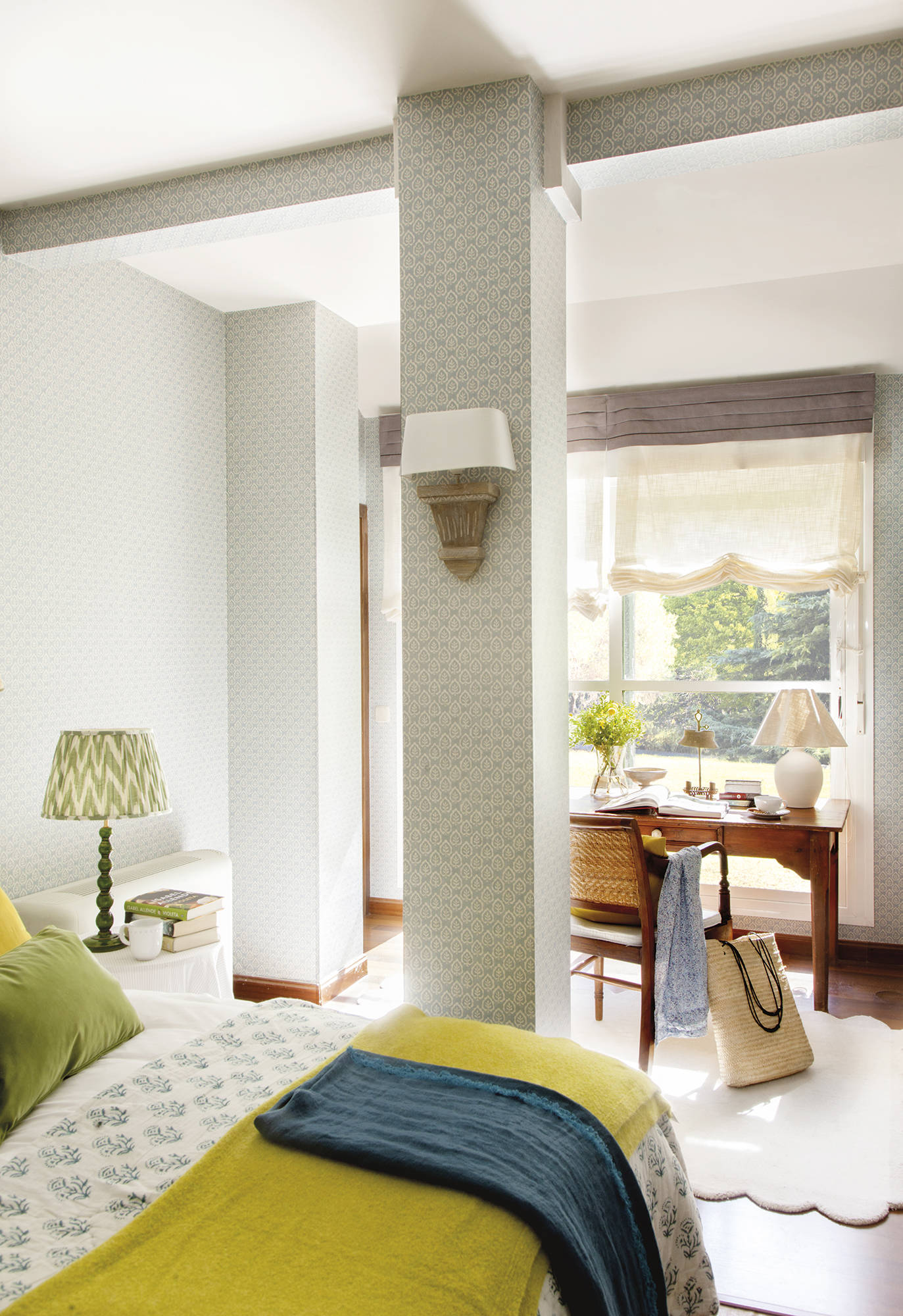 Dormitorio con escritorio de herencia de madera, y papel pintado y ropa de cama en verde.
