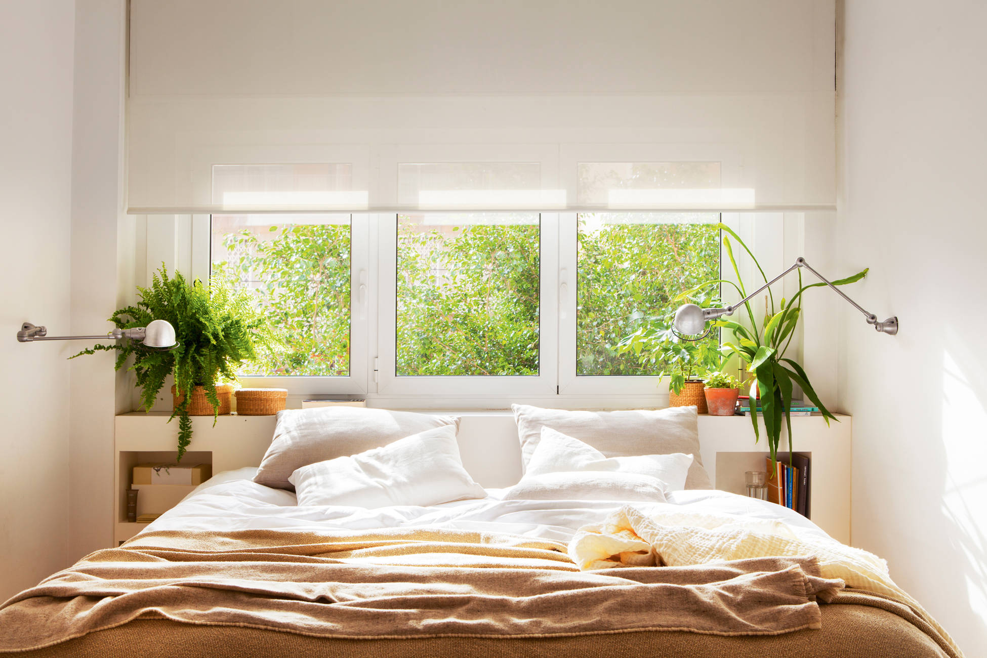 Dormitorio con cabecero decorado con plantas.