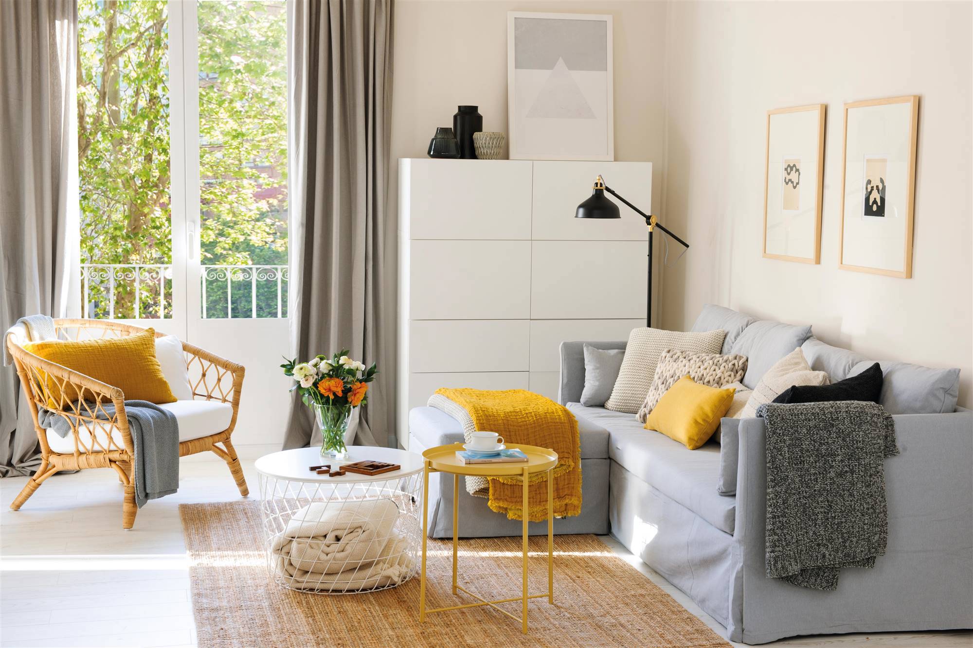 Salón con sofá cama gris con espacio de almacenamiento, mesa de centro amarilla y alfombra de fibras.
