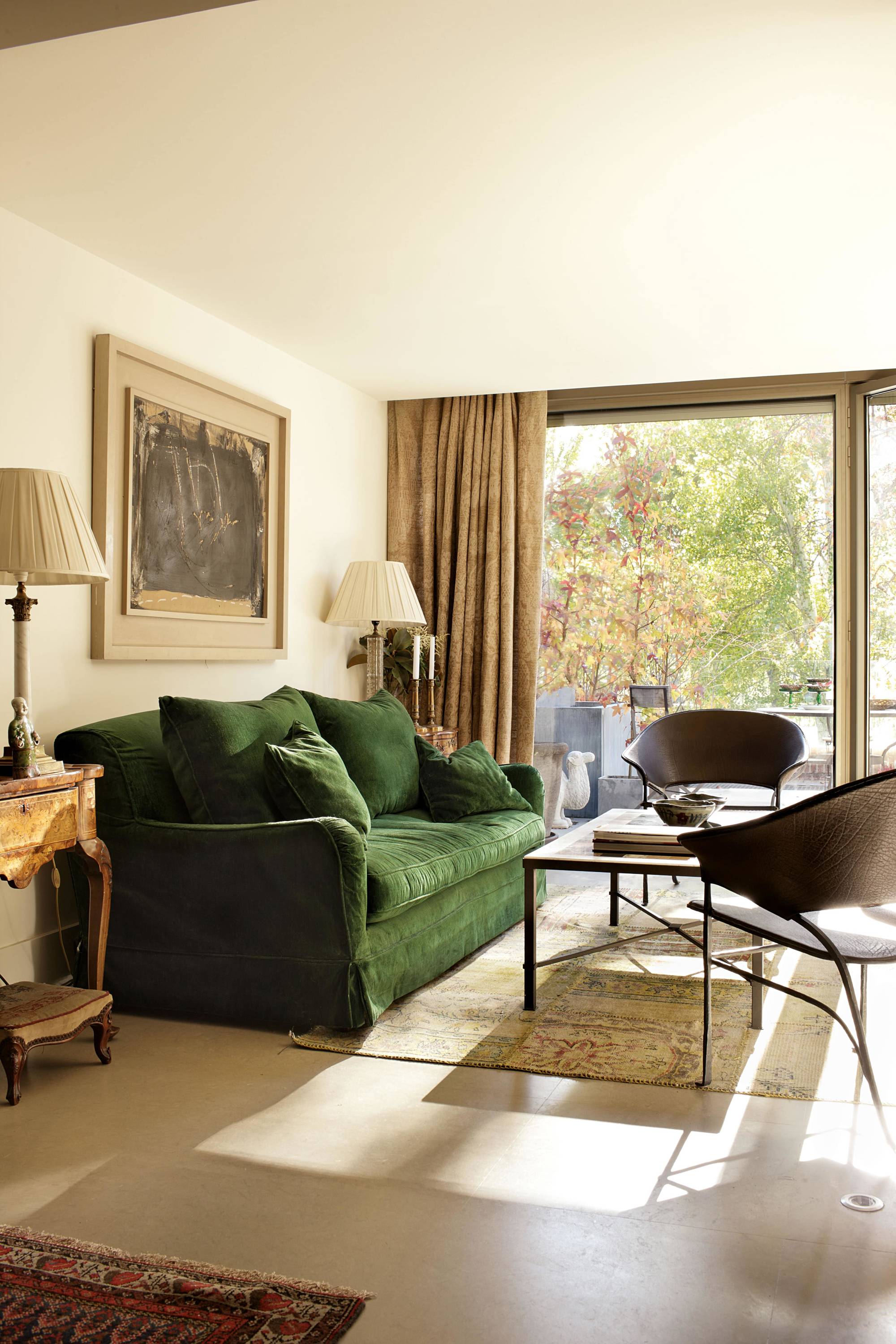 Salón clásico con sofá de terciopelo de lino verde biplaza y cortinas de lino. 