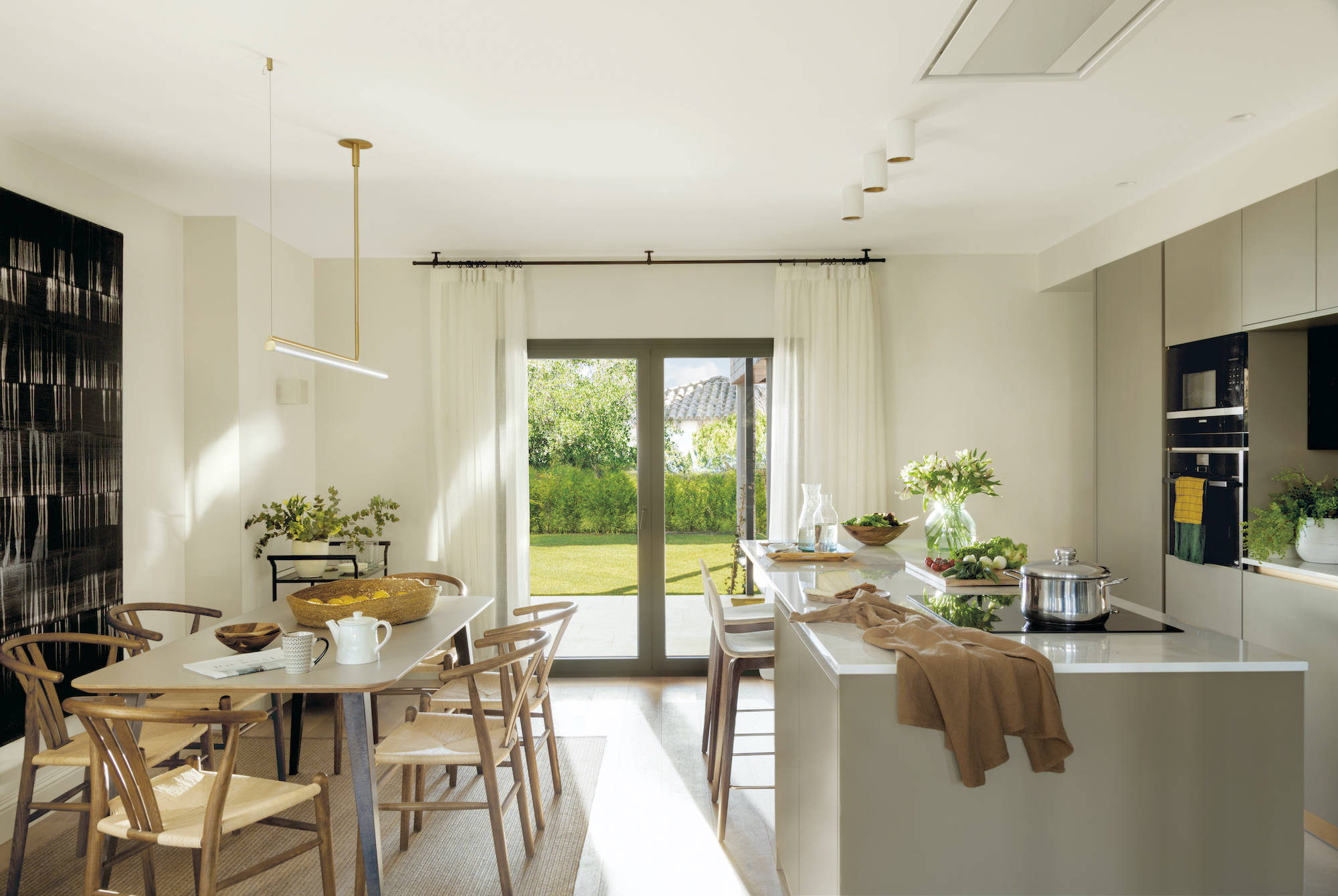 Cocina moderna con isla, paredes blancas y muebles topo. 