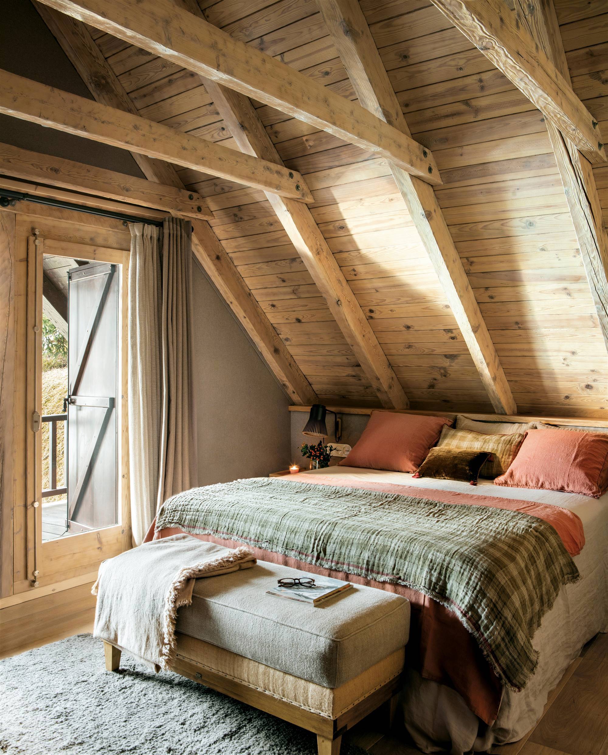 Dormitorio rústico con alfombra de lana y vigas de madera. 