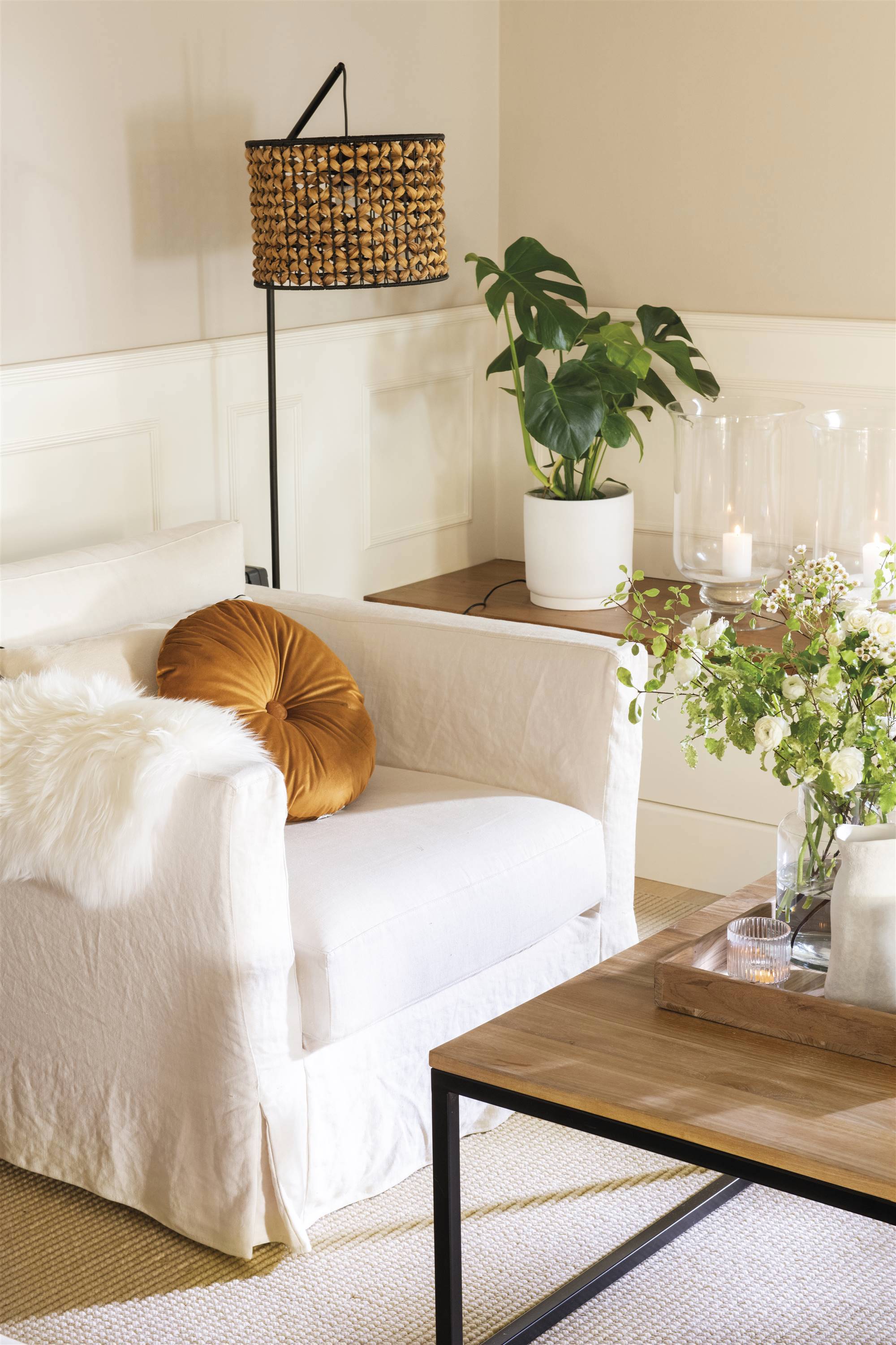 Salón con sillón blanco y alfombra. 