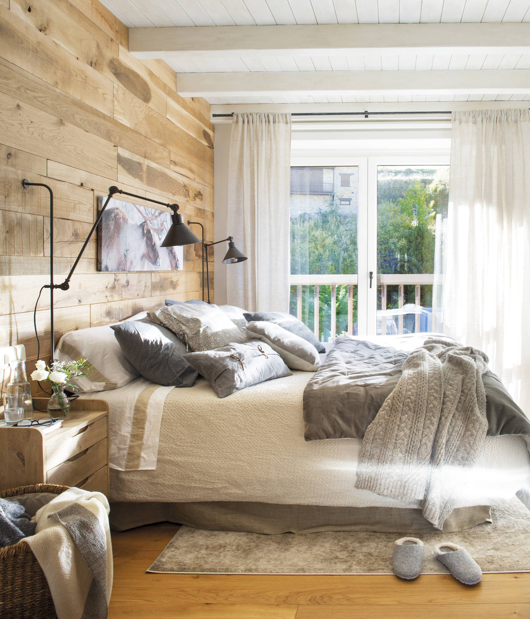 Dormitorio con pared del cabecero revestida de madera. 