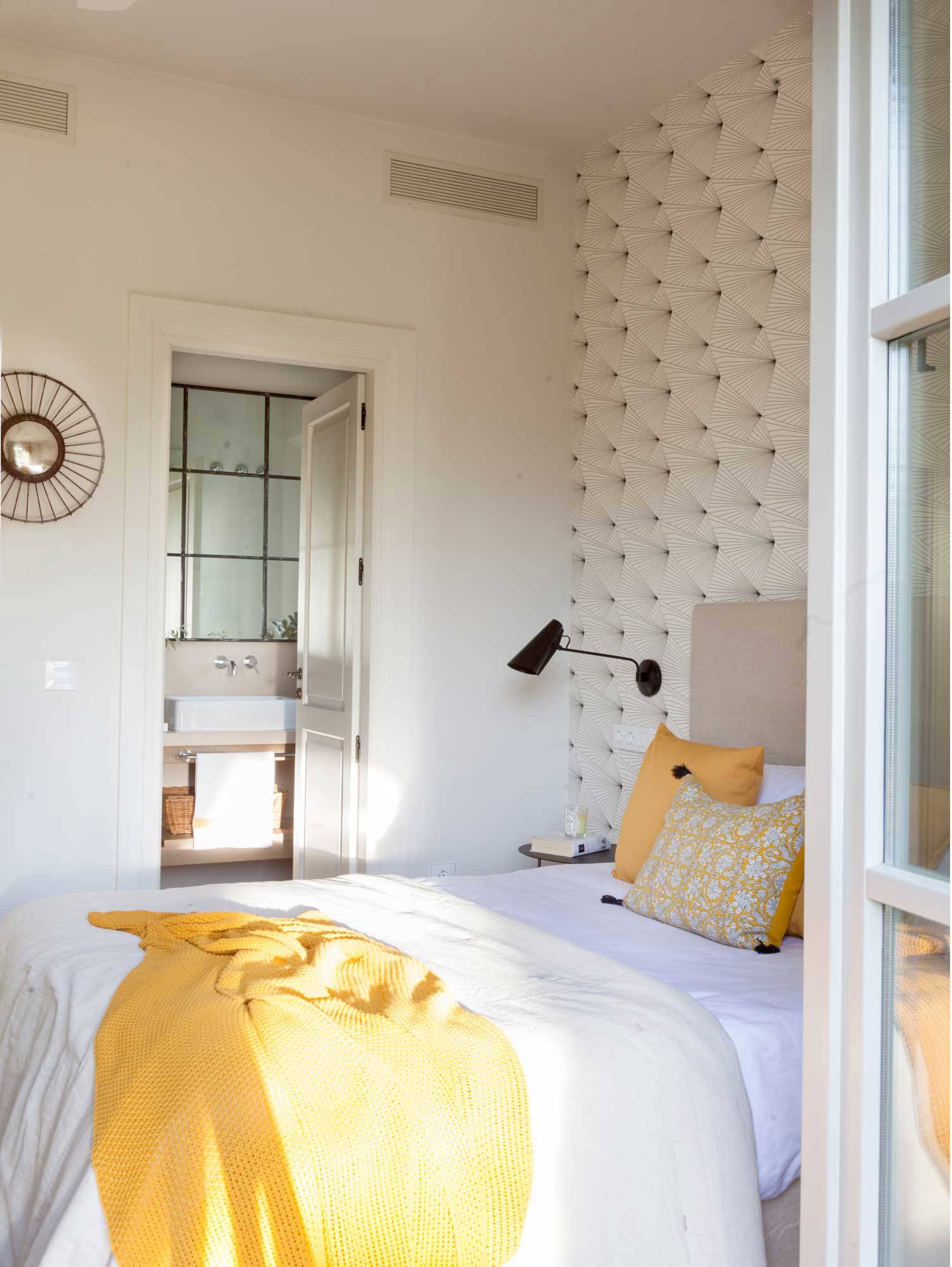 Dormitorio con papel pintado geométrico. 