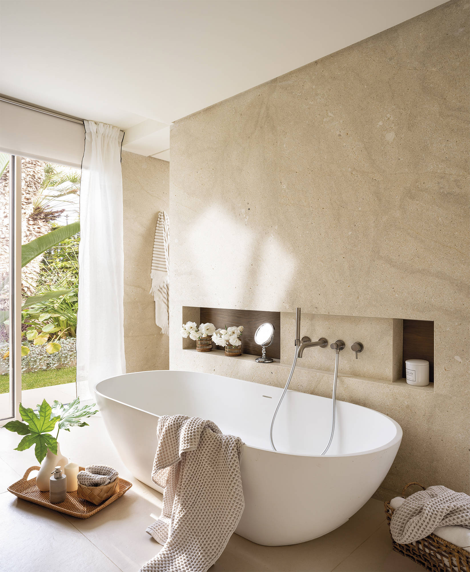 Baño con bañera exenta y pared de piedra lisa