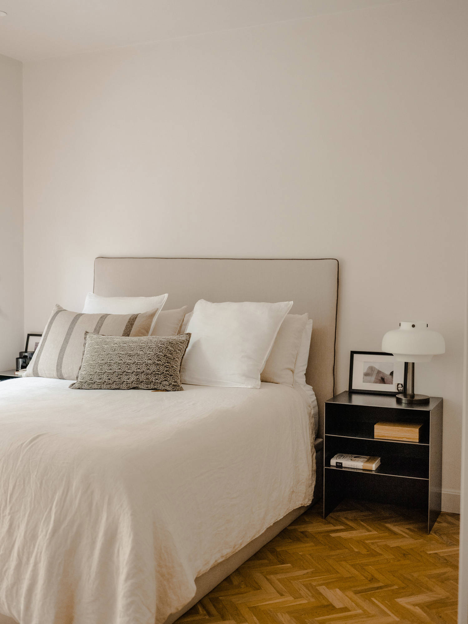 Dormitorio acogedor con suelo de madera en espiga y cabecero tapizado Elena Eyre