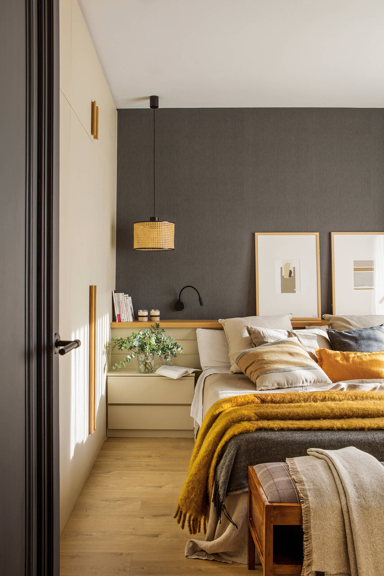Dormitorio con la pared del cabecero con papel pintado textil en color gris intenso. 