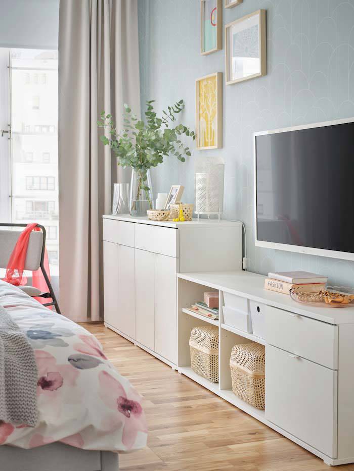 Aparador blanco y mueble TV en pared de dormitorio de IKEA.