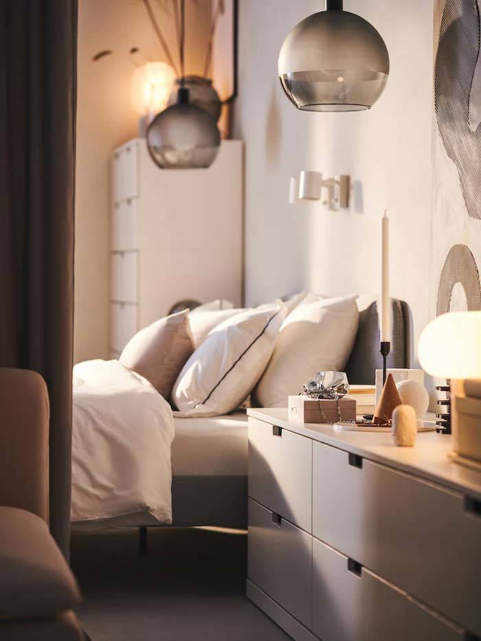 Dormitorio con cama gris y cómoda blanca de IKEA.