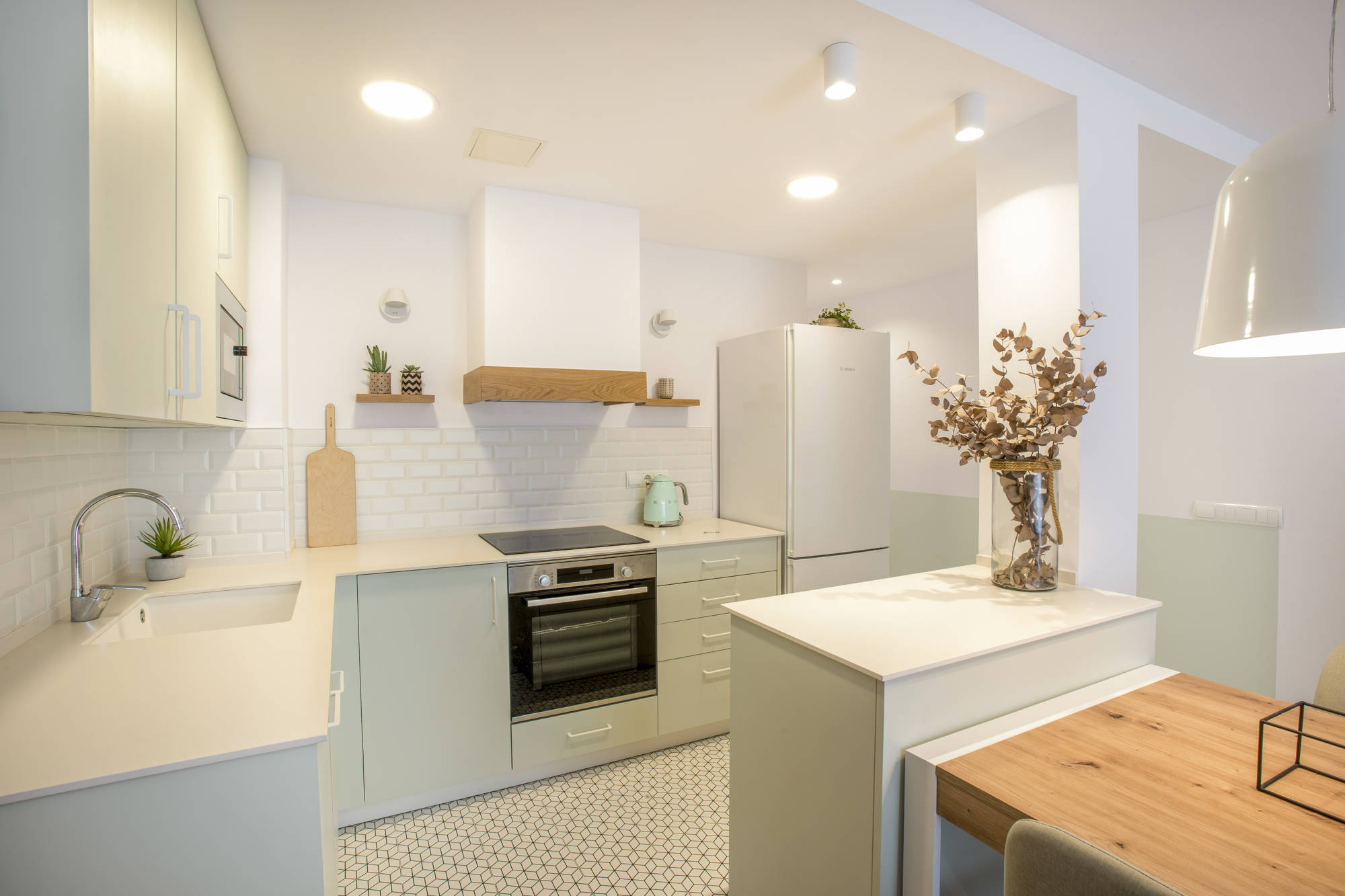 Cocina blanca y azul turquesa con suelo de baldosas con diseño. 