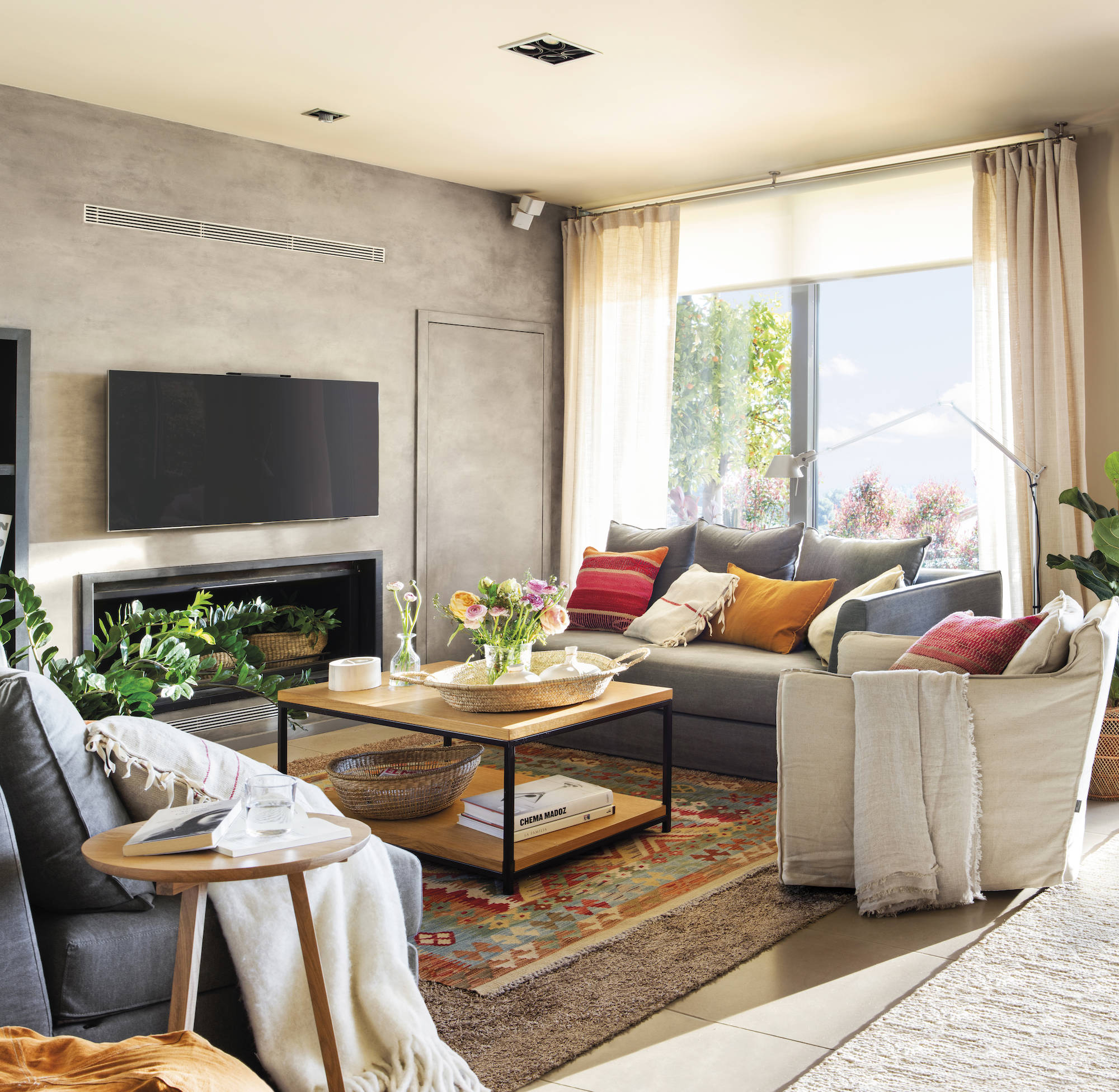 Salón con sofás en gris y alfombra superpuestas