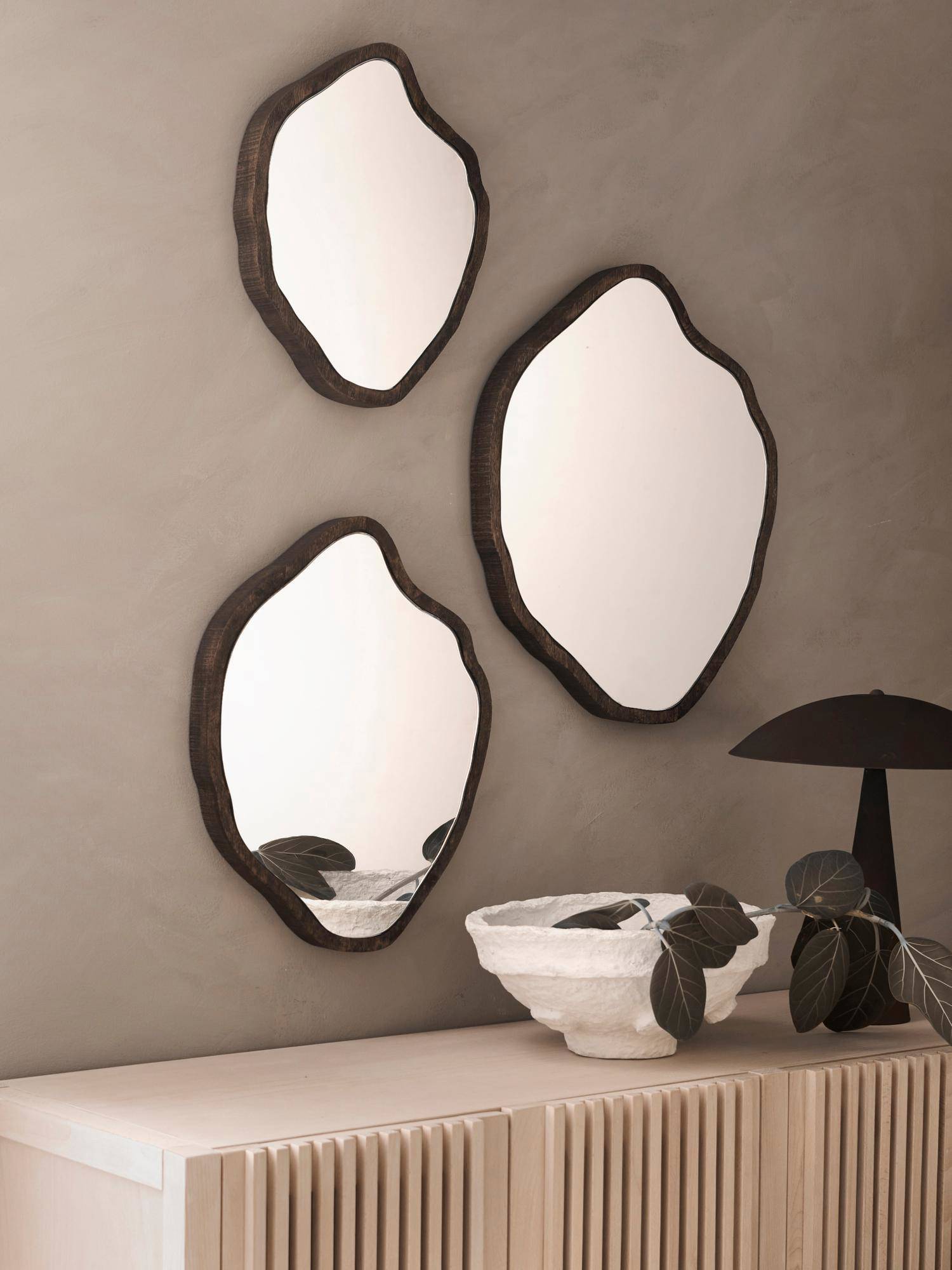 Consola blanca y tres espejos con formas redondeadas