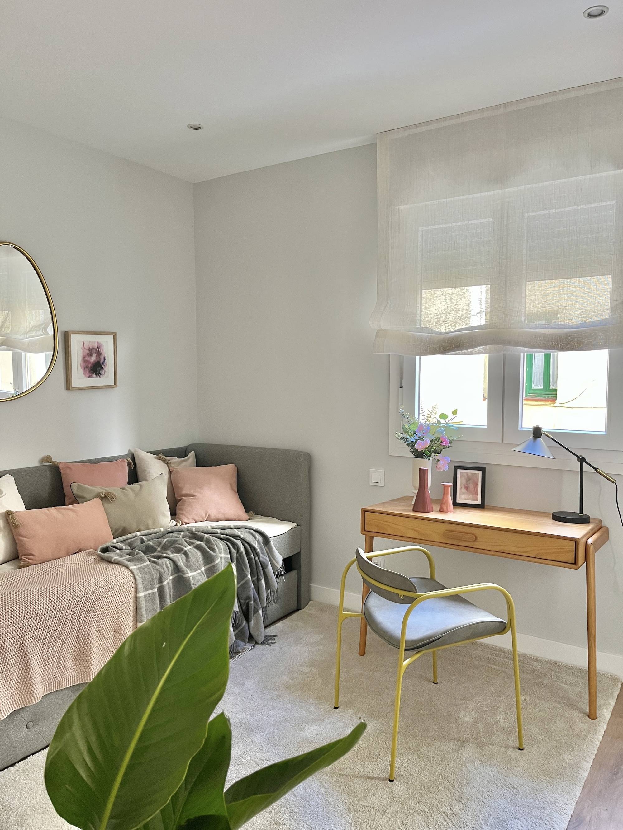 Dormitorio de invitados con sofa´ cama, escritorio de madera y alfombra por Dafne Vijande