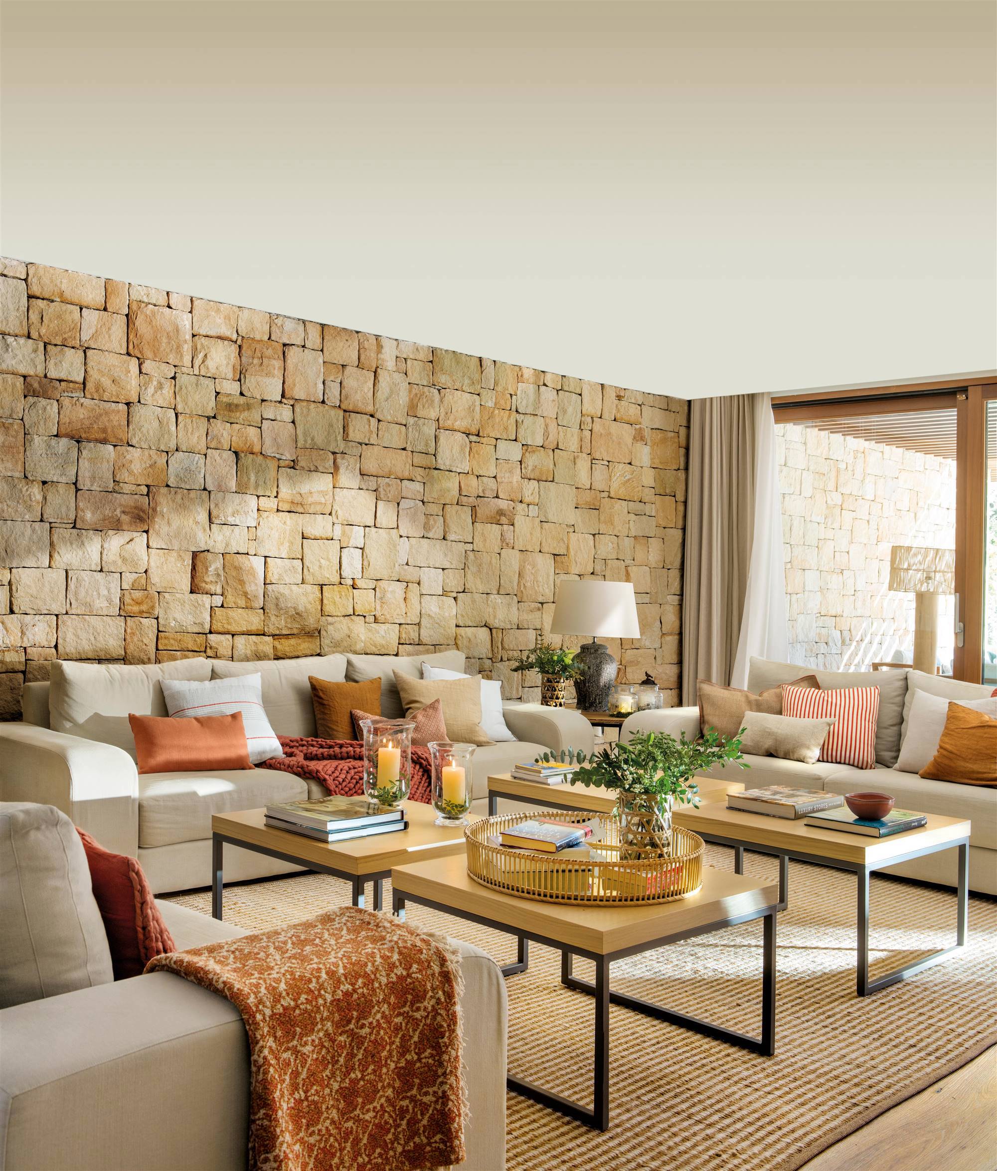 Salón beige con pared de piedra vista artesanal.