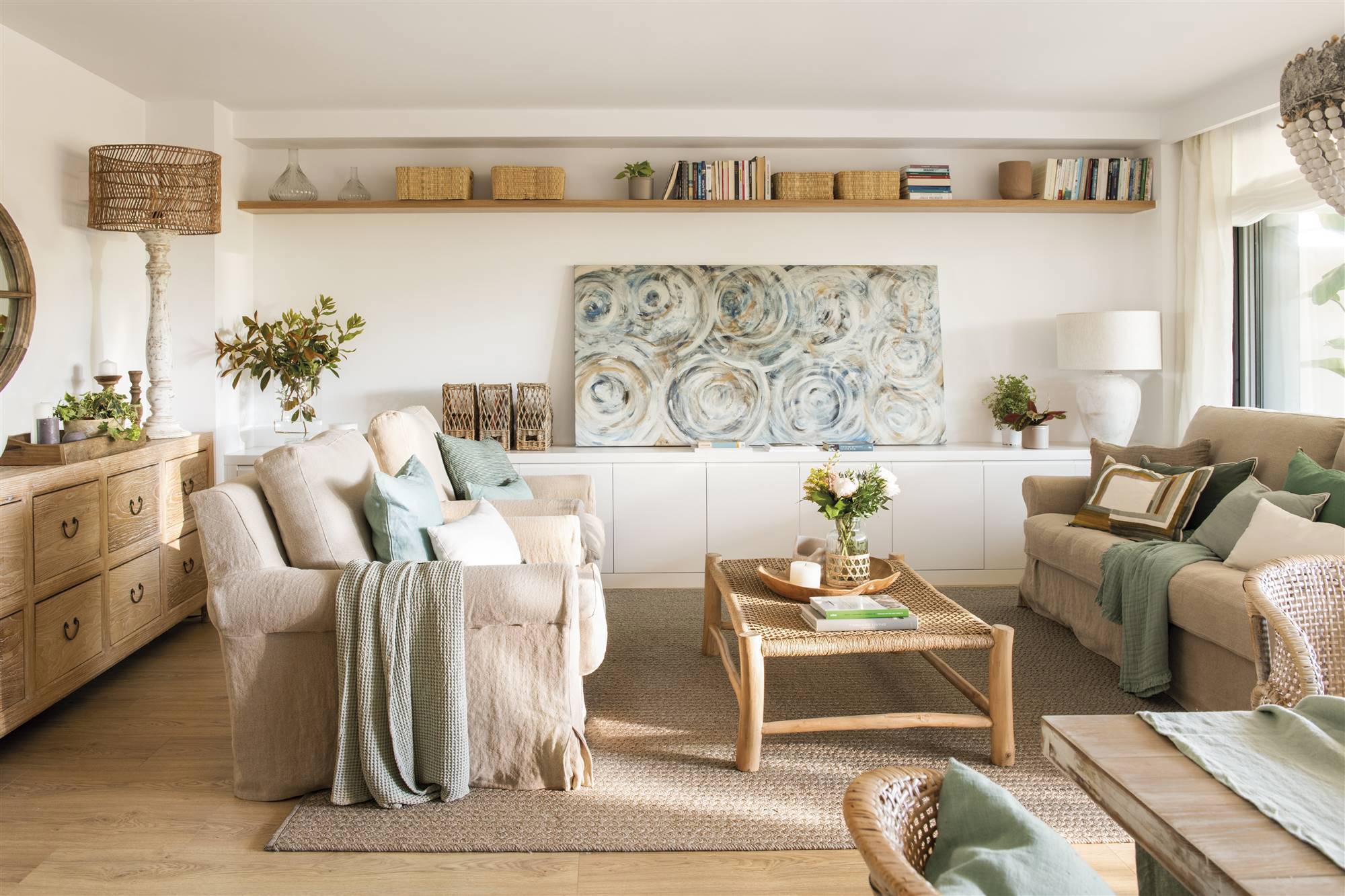Salón con sofás enfrentados de color beige, mesa de madera y cuerda y mueble bajo blanco para almacenaje.