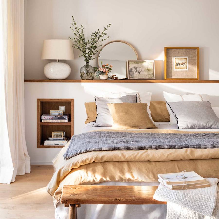 Dormitorio con cabecero murete y cama vestida en beige y gris