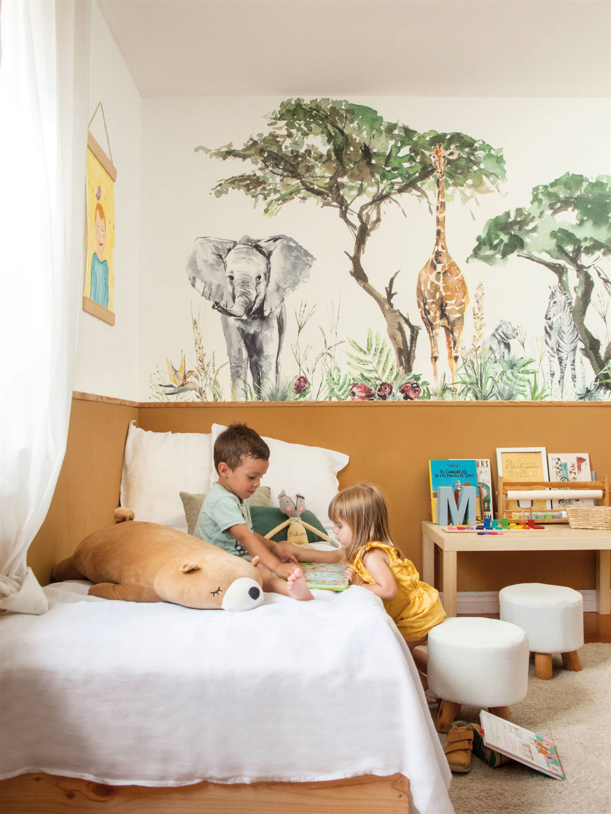 Dormitorio infantil con fotomural de animales en pared.