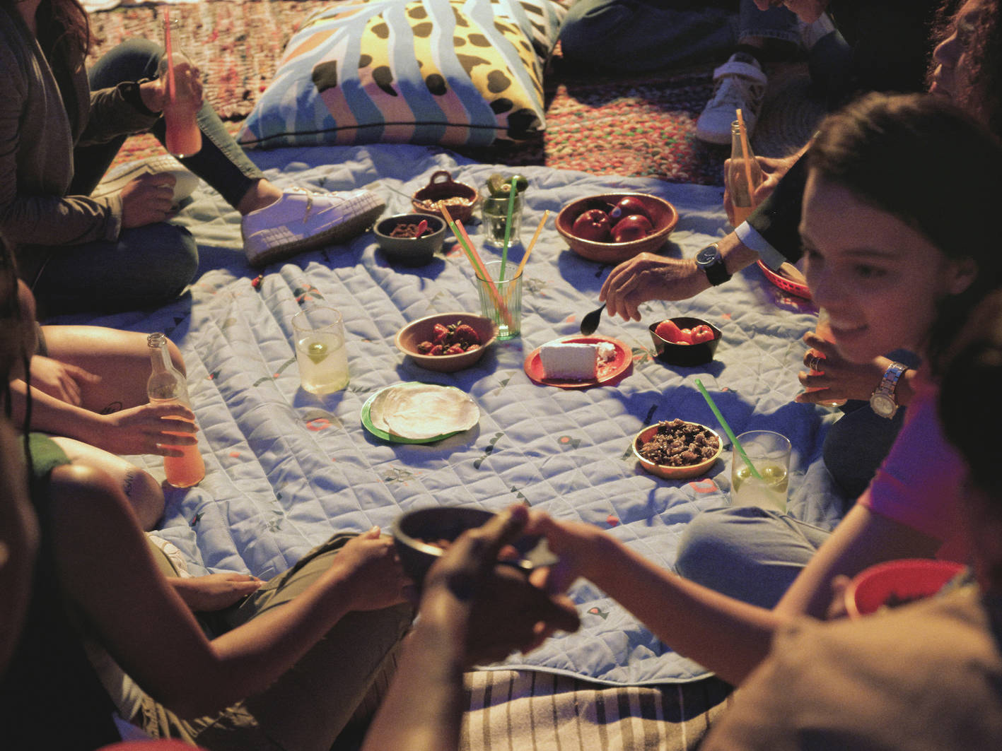 Jóvenes haciendo un picnic sobre la manta de la colección ÖMSESIDIG.
