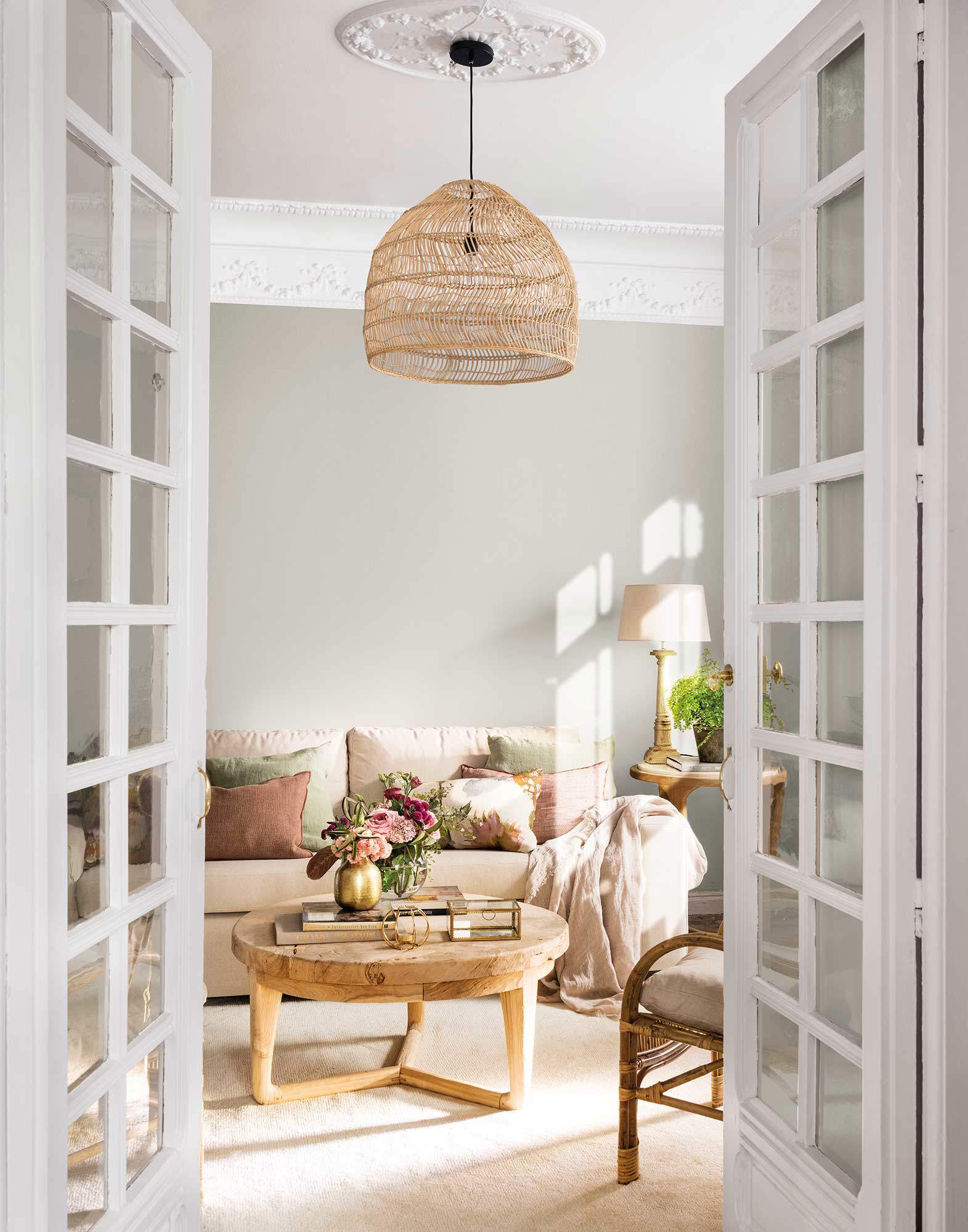 Salón decorado en tonos neutros con muebles de madera y detalles en fibra