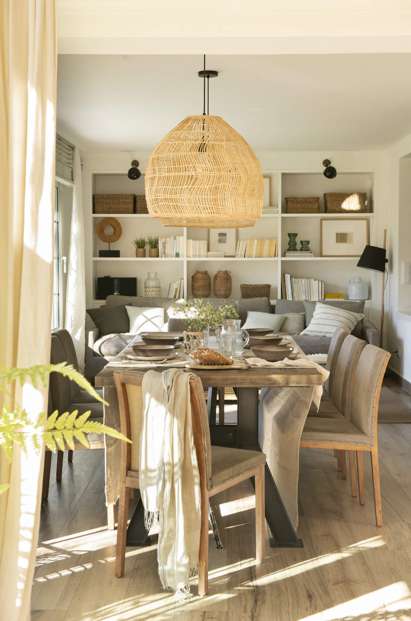 Comedor moderno con mesa de madera y sillas tapizadas con estructura a la vista.