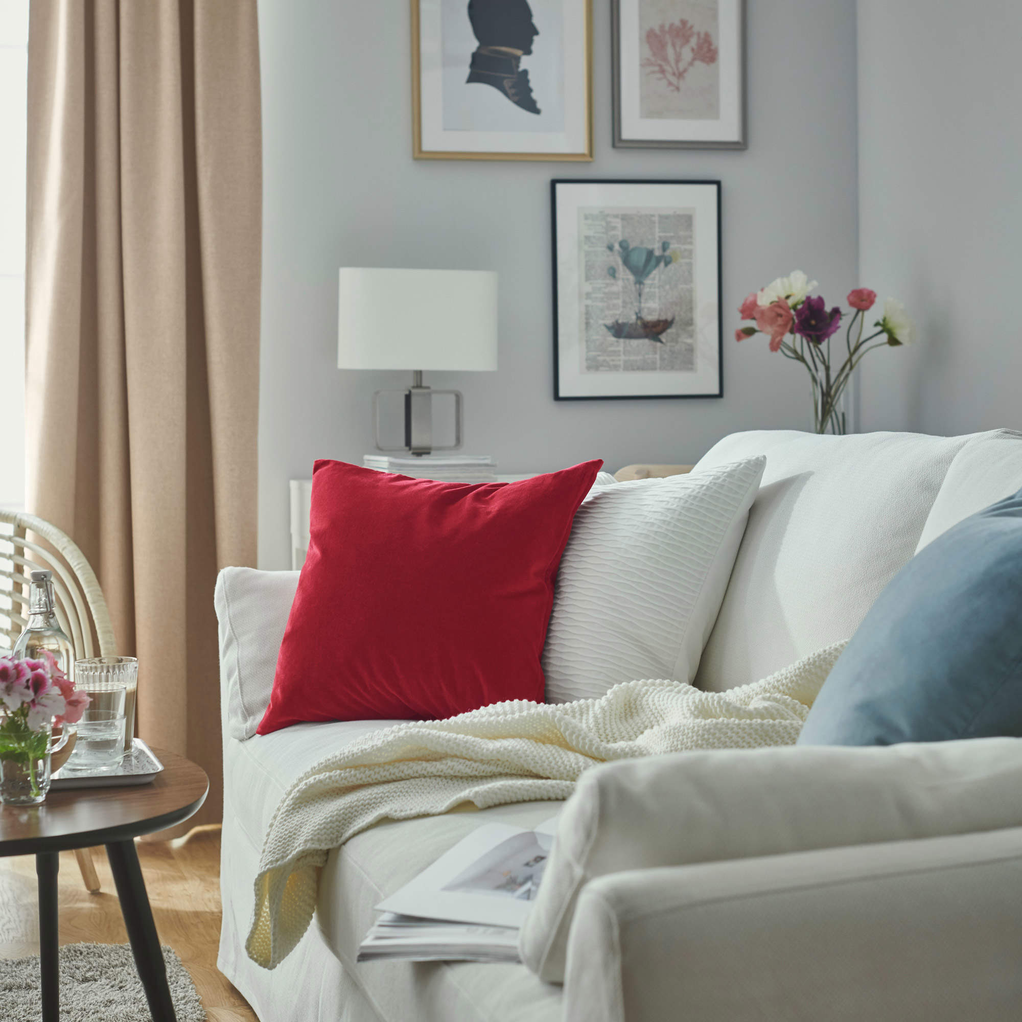 Salón con sofá blanco con cojines en rojo y azul