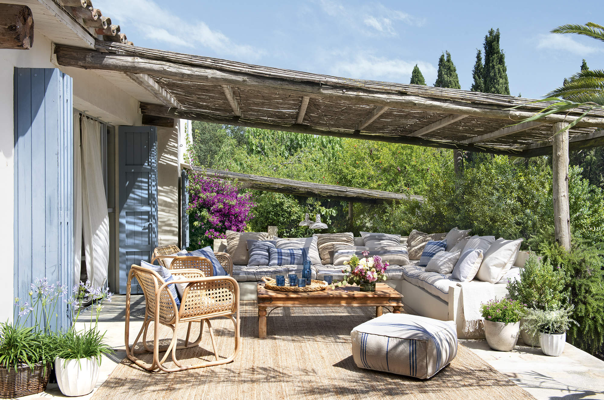 Terraza chill out con porche de madera y cañizo y sofá de obra. 