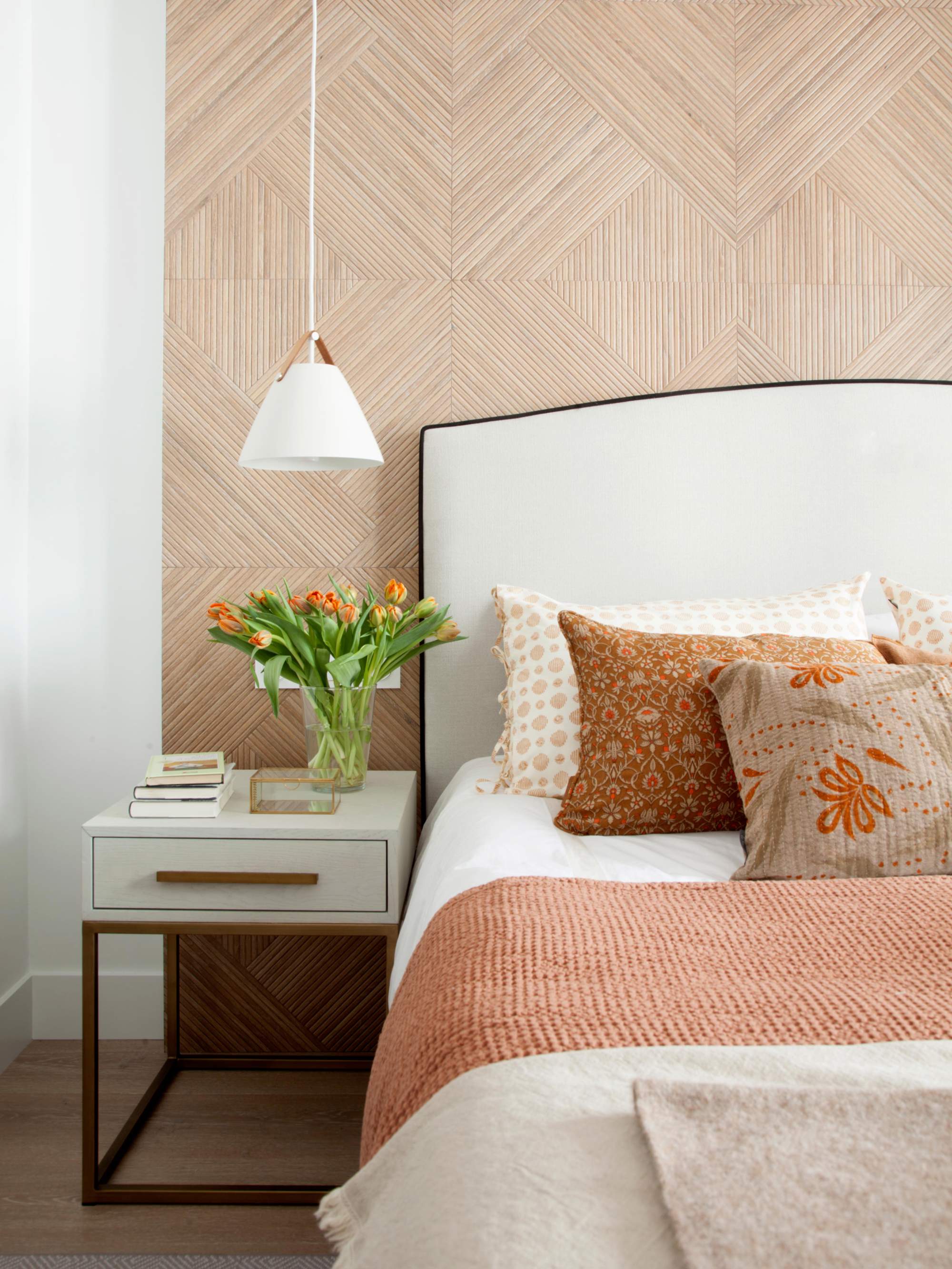 Dormitorio con pared de cabecero porcelánico imitación a madera.