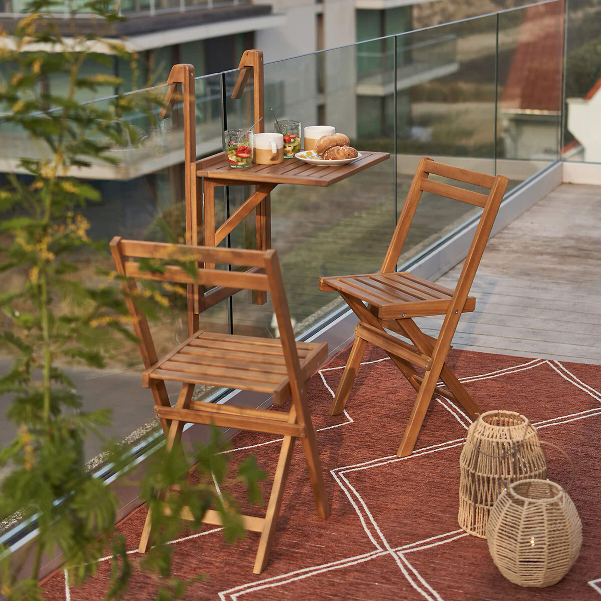 Terraza urbana con sillas plegables y mesa para colgar de la barandilla.