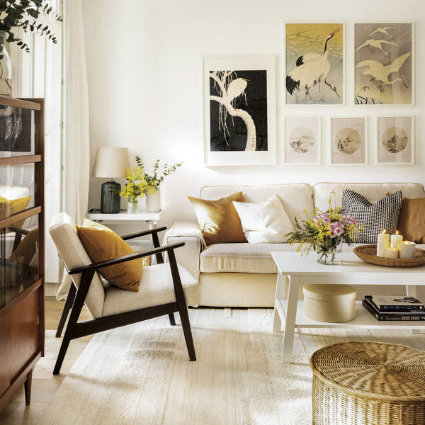 Salón blanco con sofá beige y butaca de estilo escandinavo con muebles de Ikea