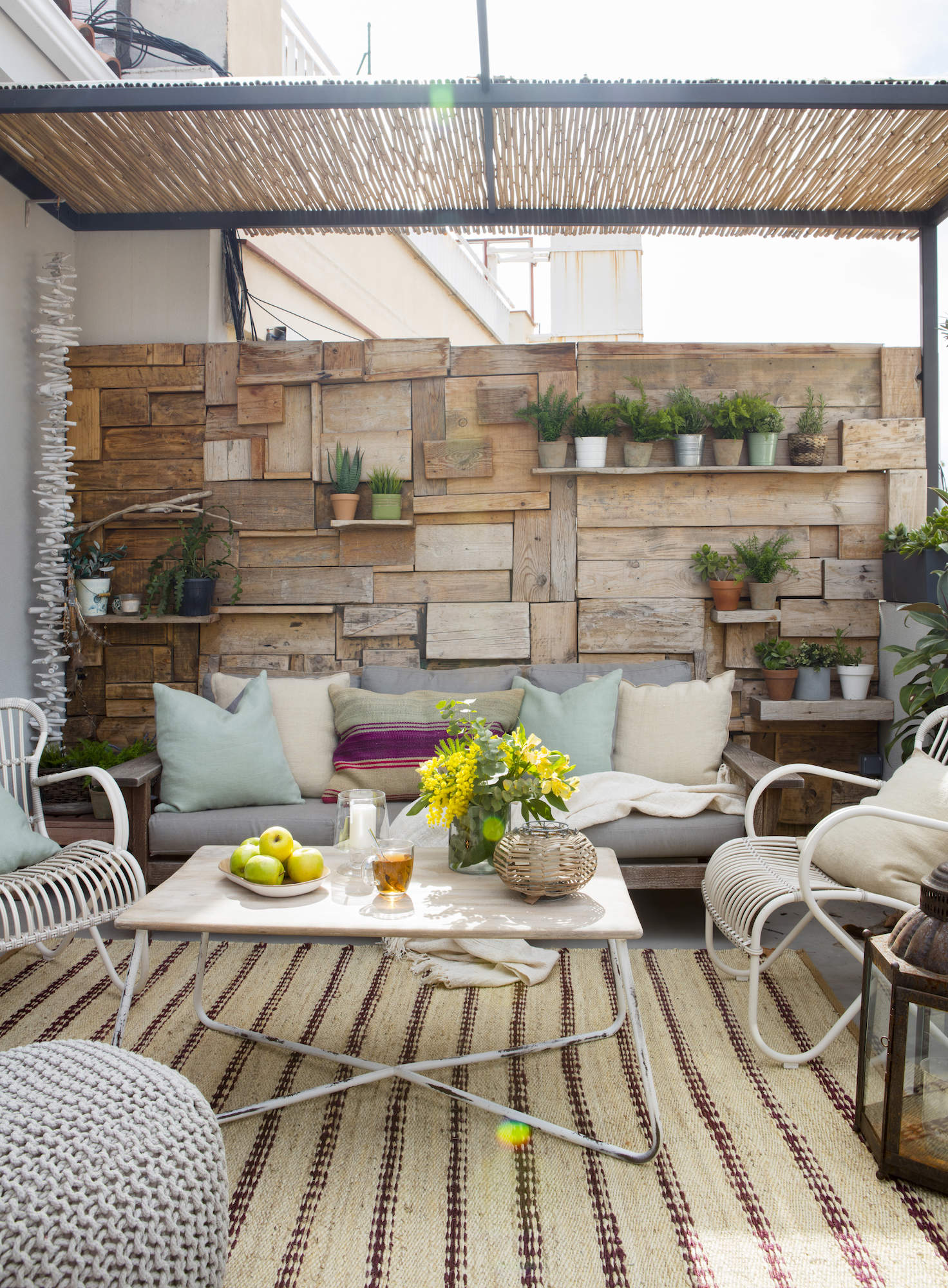 Terraza con sofás y pared de madera. 