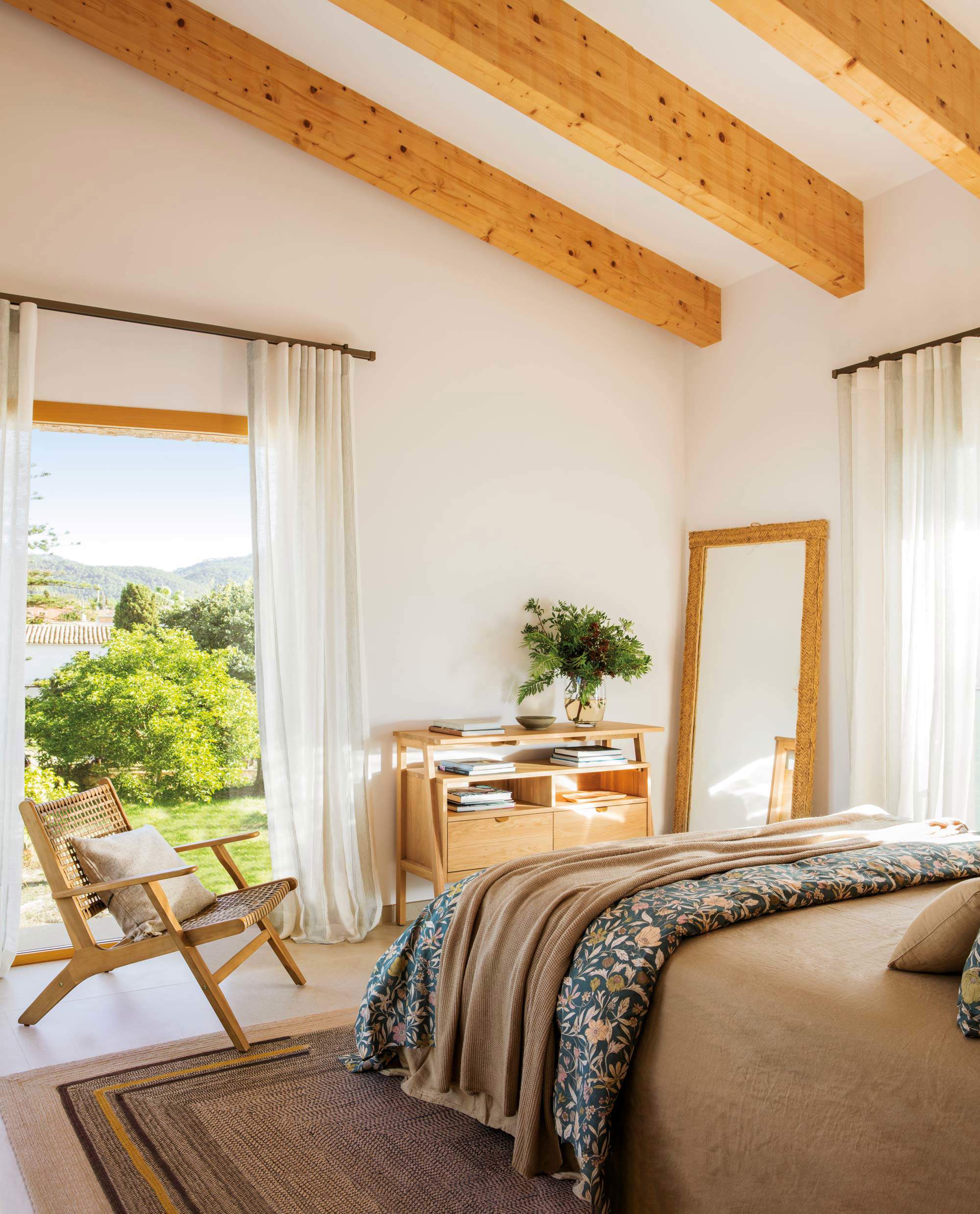 Dormitorio de verano con techo de vigas de madera y acceso al jardin