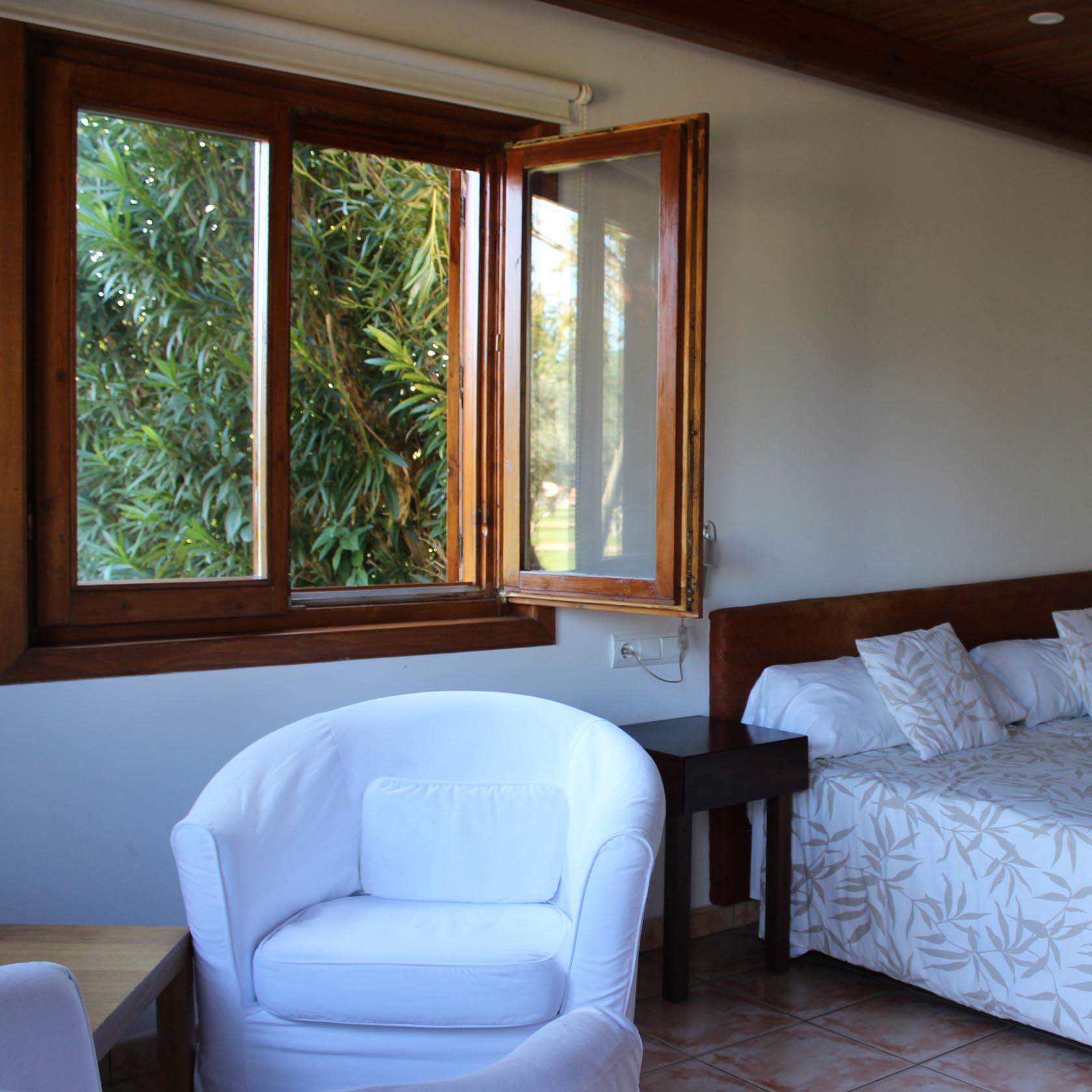 Habitación con muebles oscuros y textiles de color blanco