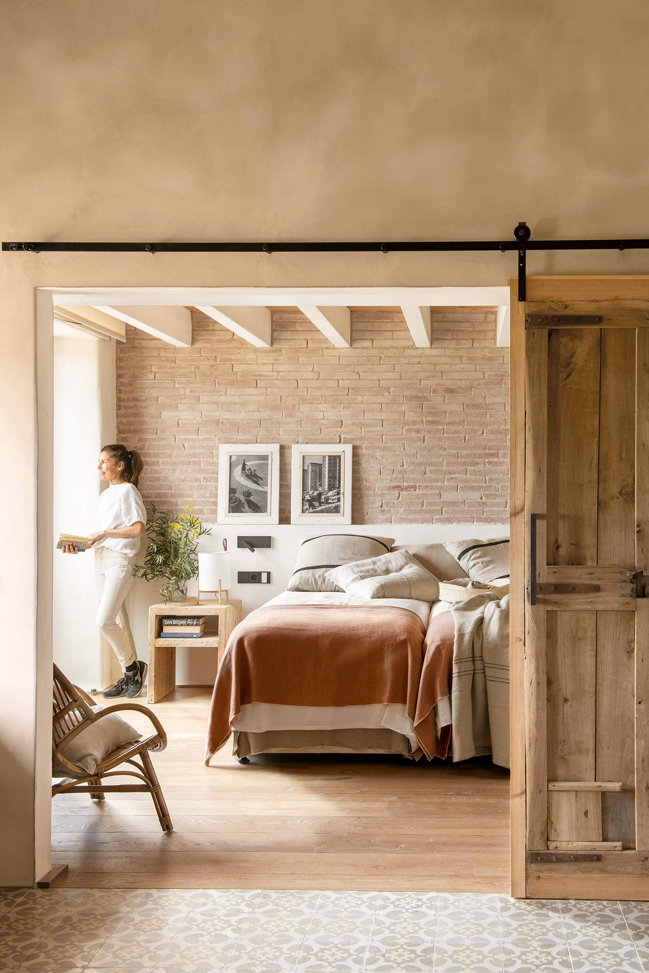 Dormitorio con puerta de granero y suelos de madera.