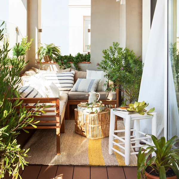 terraza cubierta con sofá rinconero mesa de  centro de caña taburete de madera y cojines vintage a rayas_420681
