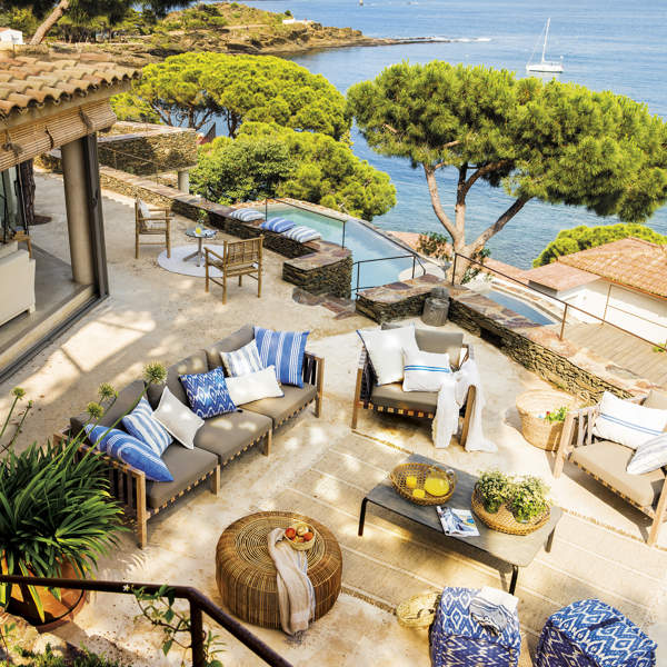 Una casa de verano de ensueño donde mandan el beige, las fibras y la madera, con terrazas a varios niveles y una piscina con vistas