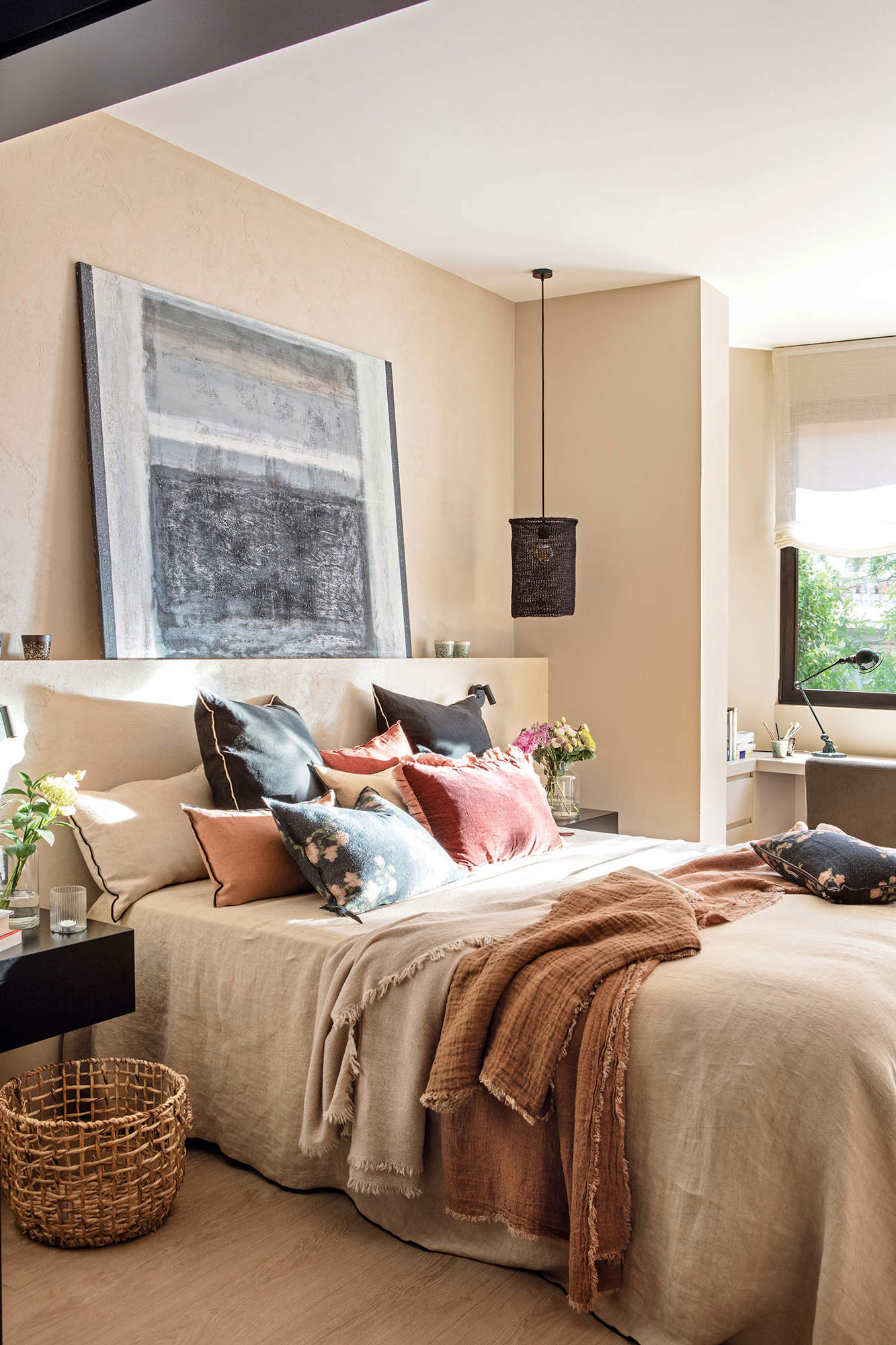 Dormitorio decorado con cuadro de grandes dimensiones sobre el cabecero y ropa de cama de estilo rústico.