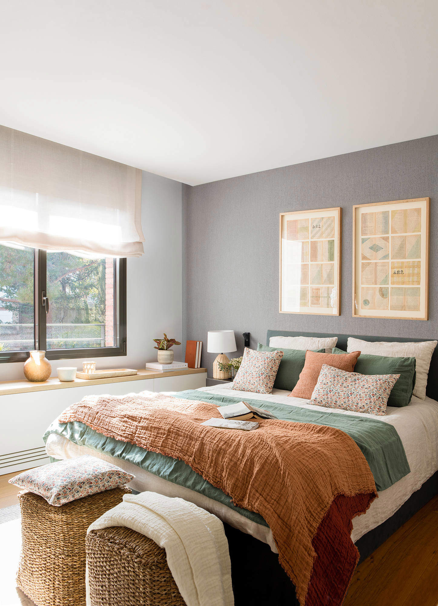 Dormitorio con papel pintado en gris, y ropa de cama en tonos tierra y verdes.