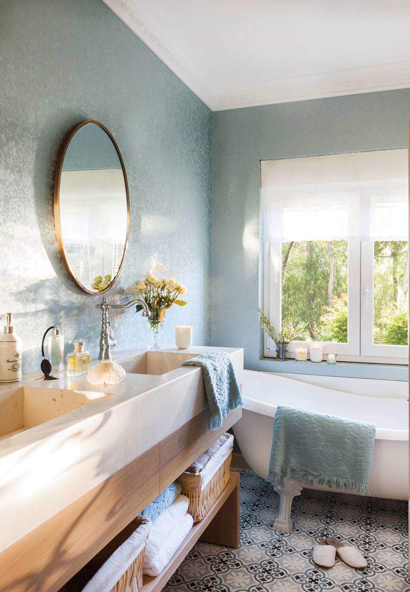 cuarto de baño gris papel pintado mueble madera espejo redondo.