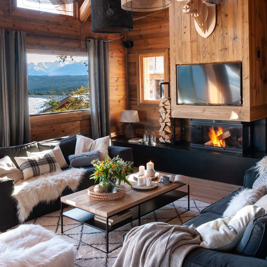 Salón de montaña con mueble de madera para chimenea y televisor