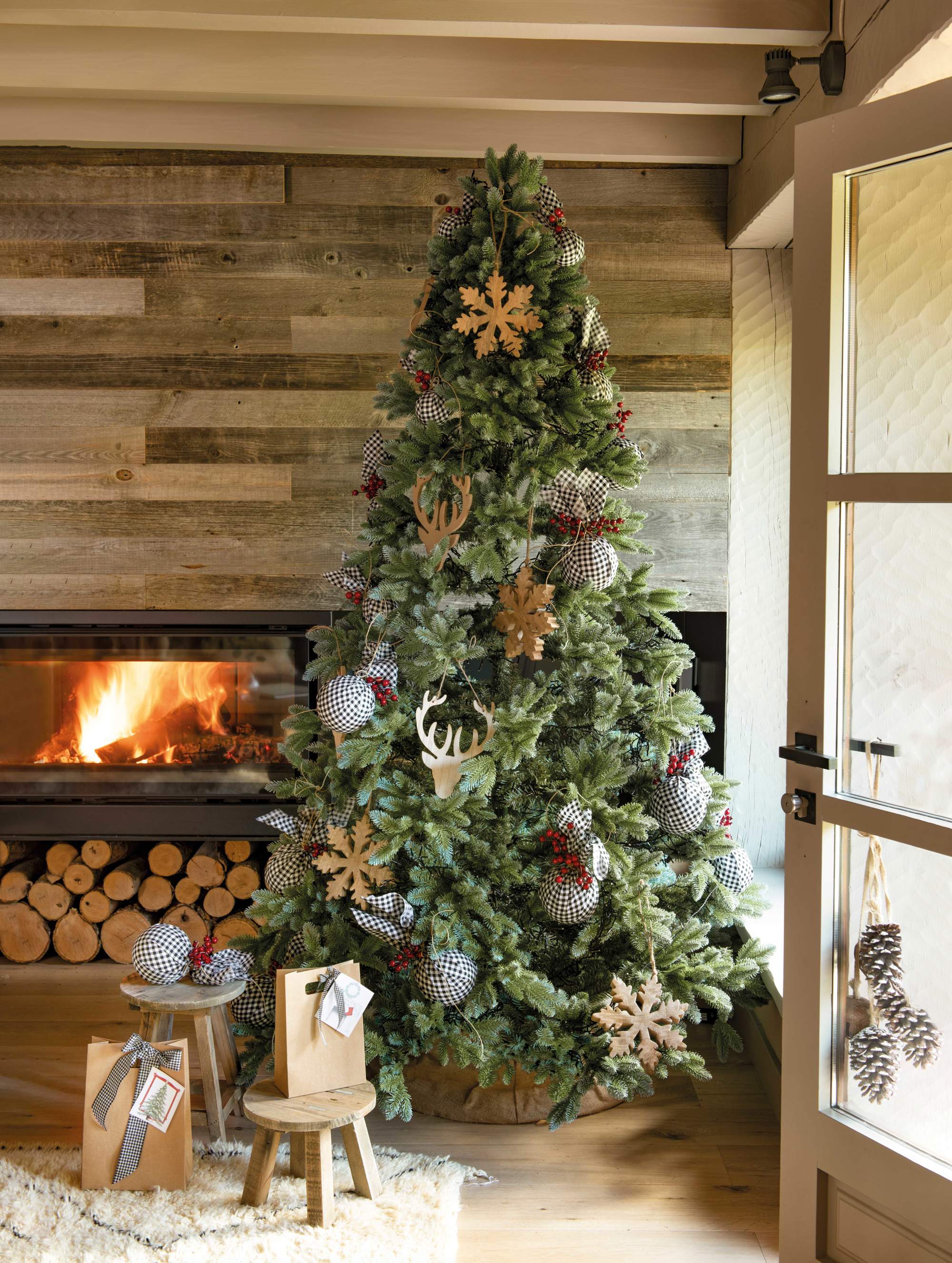 Árbol de Navidad junto a chimenea decorado con bolas forradas con tela Vichy y adornos de madera XL