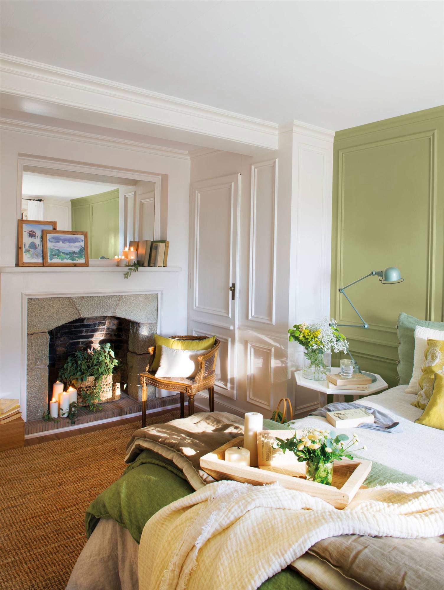Dormitorio decorado en verde y blanco con molduras y chimenea.